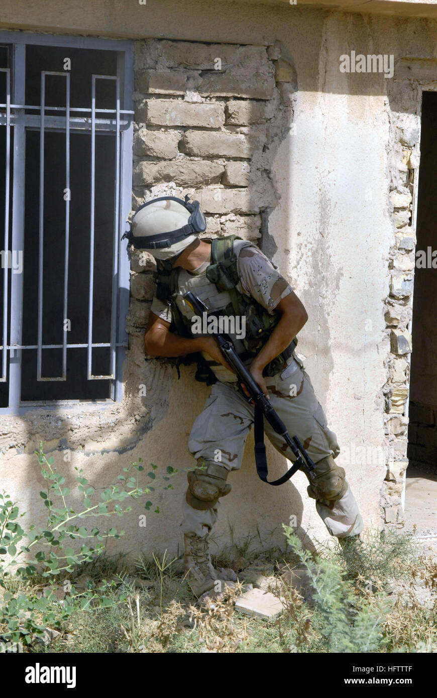070712-N-9500T-143 KHAN BANI SA'AD, Iraq (July 12, 2007) - An Iraqi army soldier peers through a window of a possible enemy position during a joint mission. Soldiers from Alpha Battery, 2nd Battalion, 12th Infantry Regiment, 2nd Infantry Division and units of the Iraqi army are conducting a cordon and search mission to clear the area of insurgents and cache sites. U.S. Navy photo by Mass Communication Specialist 2nd Class Scott Taylor (RELEASED) US Navy 070712-N-9500T-143 An Iraqi army soldier peers through a window of a possible enemy position during a joint mission Stock Photo