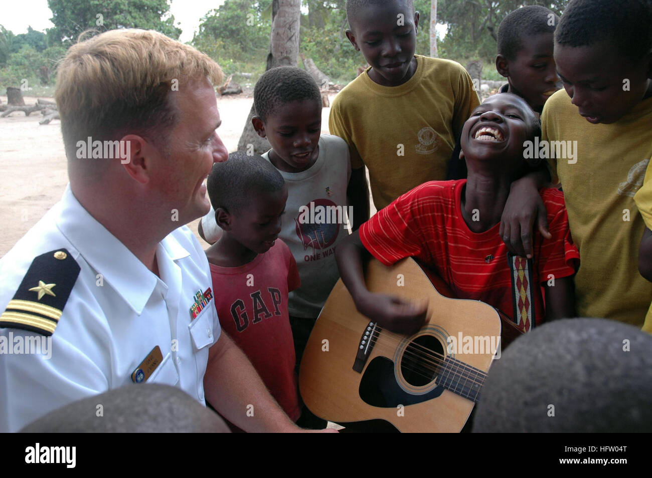 070908-N-3255B-004 DAR ES SALAAM, Tanzania (Sept. 8, 2007) - Lt. Dave Evans, assistant director of the U.S. Navy Europe-Africa Band, Topside, gives a guitar lesson to children at the Yatima Group Orphanage. Topside is aboard guided-missile destroyer USS Forrest Sherman (DDG 98), one of several ships of the NavyÕs Southeast Africa Task Group assigned to build partnerships and improve maritime security in the region. U.S. Navy photo by Gillian Brigham (RELEASED) US Navy 070908-N-3255B-004 Lt. Dave Evans, assistant director of the U.S. Navy Europe-Africa Band, Topside, gives a guitar lesson to ch Stock Photo