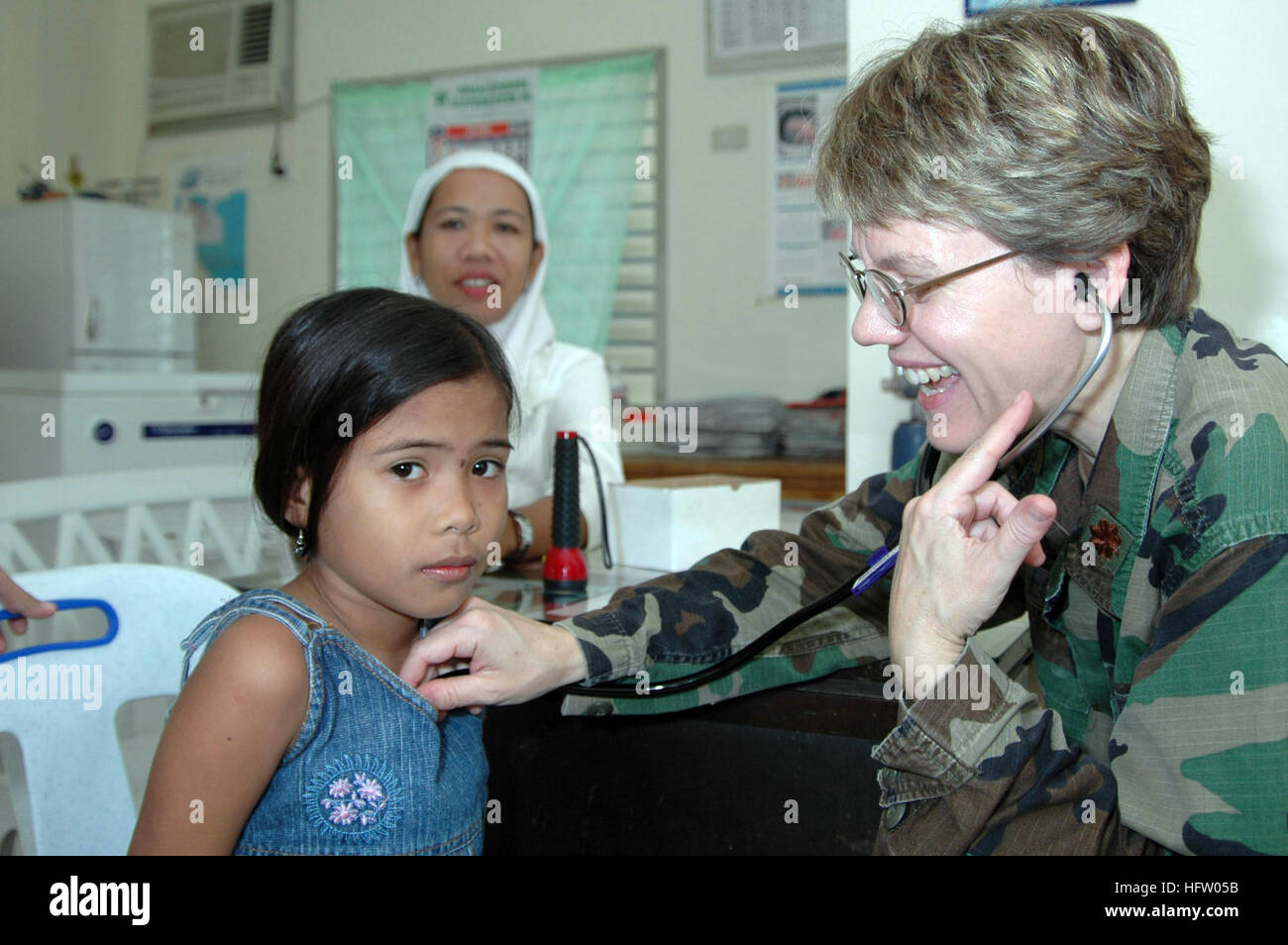 060613-N-3532C-034 Tawi Tawi, Philippines (June 13, 2006) -Air Force Maj. Valerie Clegg, a pediatrician with the Medical Treatment Facility aboard the U.S. Military Sealift Command (MSC) Hospital Ship USNS Mercy (T-AH 19), examines a young girl at Datu Halun Sakilan Memorial Hospital while the ship visits the city on a scheduled humanitarian mission. As part of its five-month humanitarian assistance deployment to South and Southeast Asia, and the Pacific Islands, the crew aboard Mercy will spend several days delivering medical care to local residents. The crew will conduct medical operations a Stock Photo