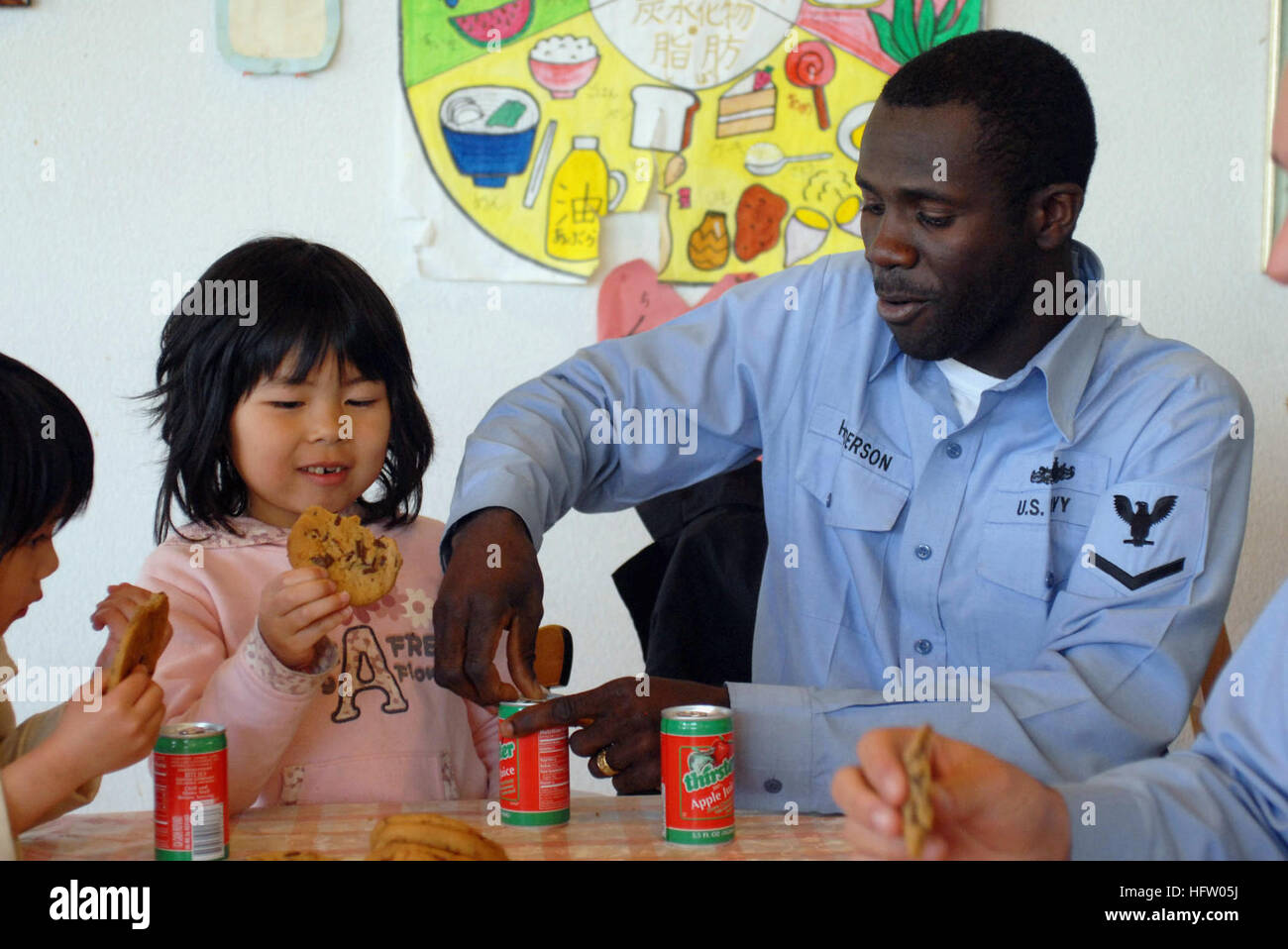 090301-N-2610F-007 FUKUOKA, Japan (March 1, 2009) Boatswain's Mate 3rd Class Barn Henderson, from Chicago, opens a can of apple juice for a child in the Kodomono-Ie Children's Home during a community service project. Sailors from the Arleigh Burke-class guided missile destroyer USS Preble (DDG 88) volunteered to spend time during their port visit to Japan with children separated from their parents. Preble, part of the John C. Stennis Carrier Strike Group, is on a scheduled six-month deployment to the western Pacific Ocean. (U.S. Navy photo by Mass Communication Specialist 2nd Elliott Fabrizio/ Stock Photo