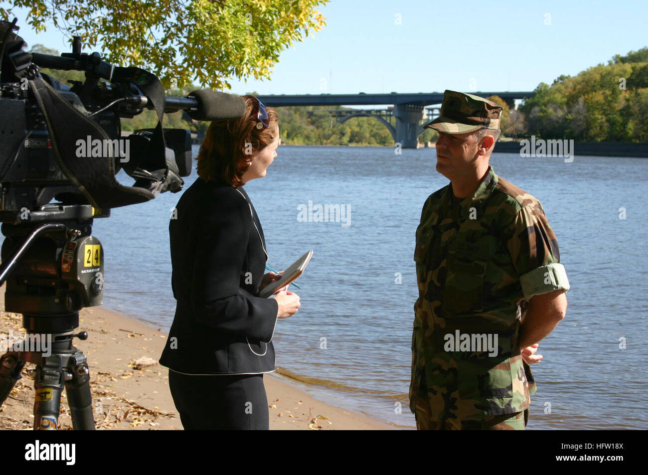 071003-N-7163S-001 MINNEAPOLIS (Oct. 3, 2007) - Cmdr. Dan Shultz, commanding officer of Mobile Diving and Salvage Unit (MDSU) 2, interviews with KSTP-TV reporter Colleen Mahoney along the banks of the Mississippi River near downtown Minneapolis. MDSU-2 returned to the area to participate in Twin Cities Navy Week after spending much of August assisting local, state and federal authorities with finding missing victims in the wake of the I-35W bridge collapse. Navy Weeks are designed to show Americans the investment they have made in their Navy and to increase awareness of the Navy in cities that Stock Photo