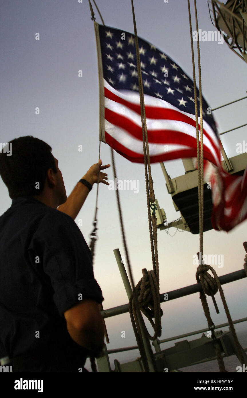071003-N-4774B-017 PACIFIC OCEAN (Oct. 03, 2007) - Quartermaster 2nd Class Jesus Aguilar lowers the national ensign at sunset aboard amphibious assault ship USS Tarawa (LHA 1). Tarawa is conducting routine training operations with the 11th Marine Expeditionary Unit off the coast of Southern California. U.S. Navy photo by Mass Communication Specialist 3rd Class Daniel A. Barker (RELEASED) US Navy 071003-N-4774B-017 Quartermaster 2nd Class Jesus Aguilar lowers the national ensign at sunset aboard amphibious assault ship USS Tarawa (LHA 1) Stock Photo
