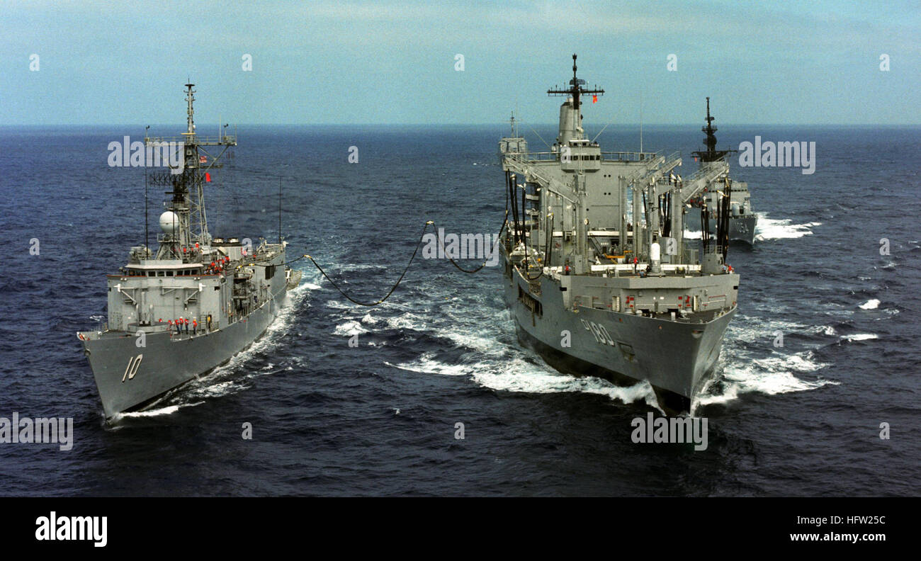 An aerial view of the US Navy (USN) Cimarron Class Oiler USS WILLAMETTE (AO 180) (center) as she services the USN Oliver Hazard Perry Class Frigate USS DUNCAN (FFG 10), (left) during an Underway Replenishment (UNREP) at sea as the USN Knox Class Frigate USS GRAY (FF 1054) follows in trail.  Exact date shot unknown. USS Willamette, Duncan, and Gray 02 Stock Photo