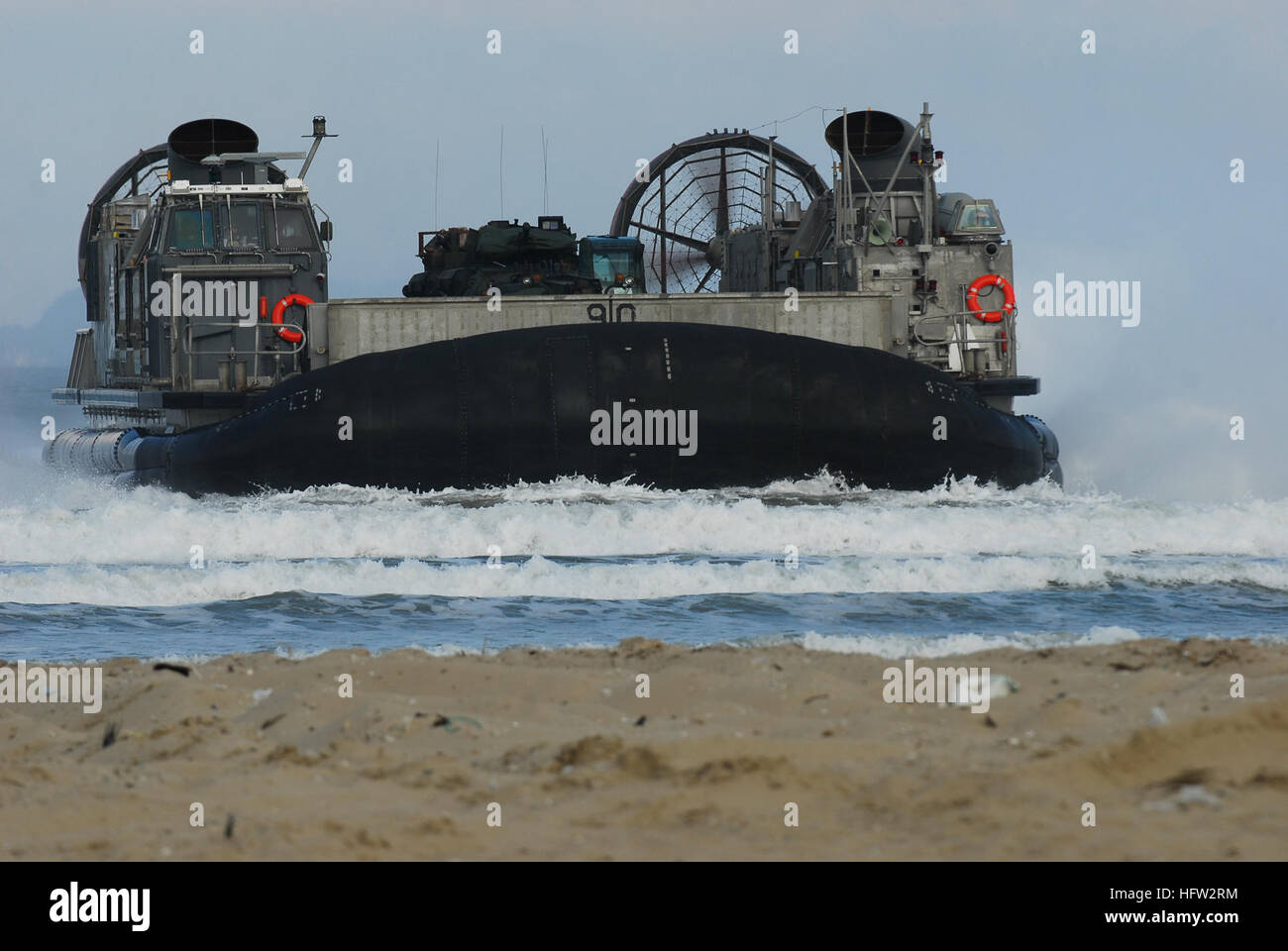 071111-N-0120A-085  PO HANG, Korea (Nov. 11, 2007)  Landing Craft Air Cushion (LCAC) 90, from the ÒDragonsÓ of Assault Craft Unit (ACU) 5 Det. Western Pacific, rides in the surf to the beach at Po Hang. LCACs from ACU-5 spent the day transiting to and from the amphibious assault ship USS Essex (LHD 2) in order to embark U.S. and Republic of Korea Marines. Essex is the lead ship of the only forward-deployed U.S. Expeditionary Strike Group and serves as the flagship for CTF 76, the Navy's only forward-deployed amphibious force commander. Task Force 76 is headquartered at White Beach Naval Facili Stock Photo