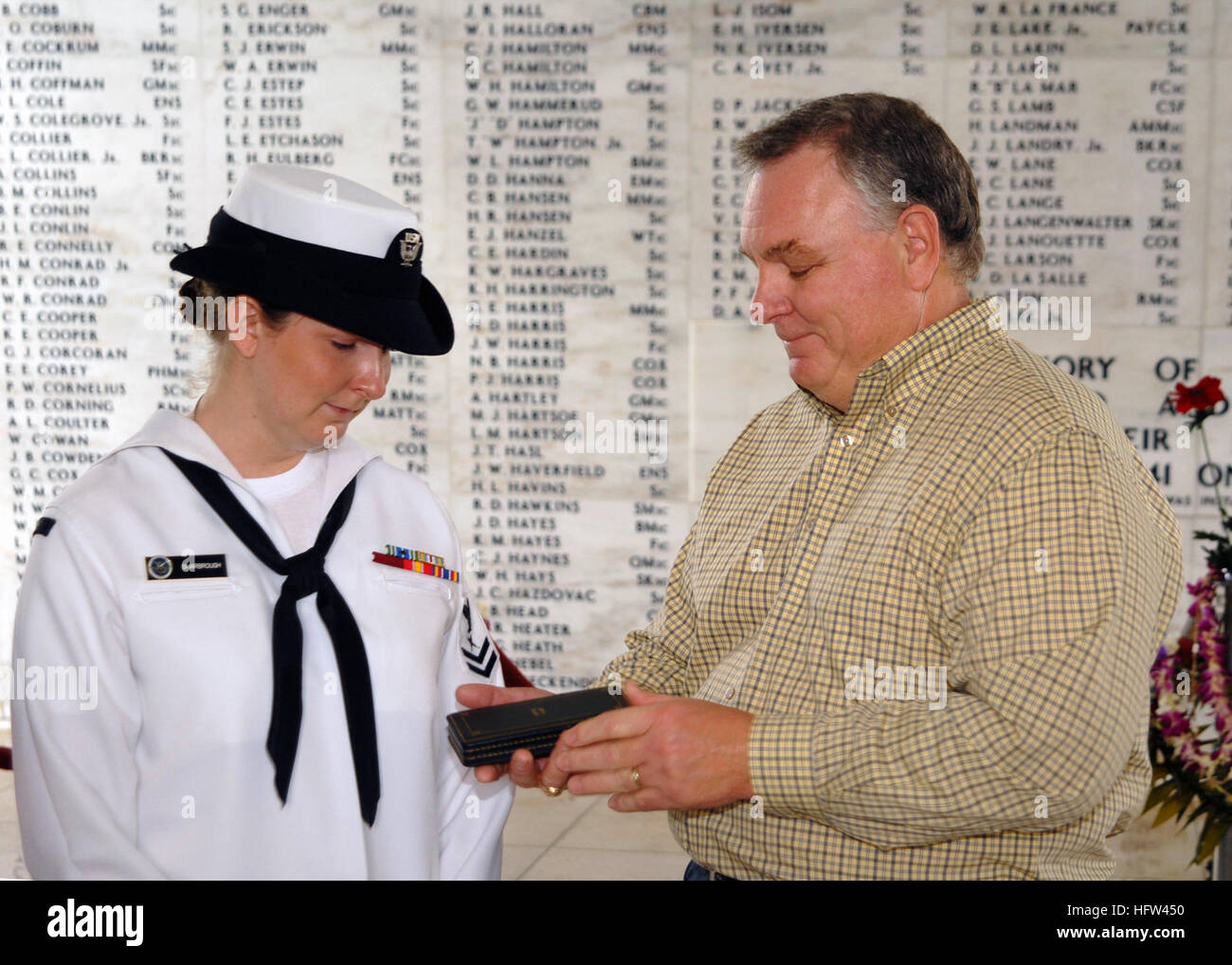 071207-N-5476H-234  PEARL HARBOR  (Dec. 7, 2007) Ð Tim Hodges presents his niece Cryptologic Technician Interpretive 2nd Class Bailey Sharbrough with the Purple Heart awarded to her great uncle Garris Hodges aboard the USS Arizona Memorial.  CTI2 Sharbrough reenlisted 66 years after her great uncle, Fireman 2nd Class Garris Hodges, perished along with 1,177 other Sailors and Marines on USS Arizona (BB 39).   U.S. Navy Photo by Mass Communication Specialist 2nd Class Michael Hight. US Navy 071207-N-5476H-234 Tim Hodges presents his niece, Cryptologic Technician Interpretive (CTI) 2nd Class Bail Stock Photo