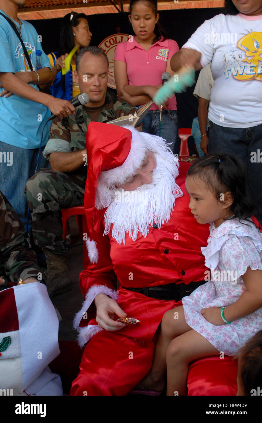 071215-N-7286M-095 ZAMBOANGA CITY, Philippines (Dec. 15, 2007) Lt. Christopher T. Auger reads a storybook as Lt. j.g. Darren E. Denyar, dressed as Santa Claus, greets children at MEIN College. Sailors, Airmen and Soldiers assigned to Joint Special Operations Task Force-Philippines (JSOTF-P) assisted MEIN College, INC. and the Kiwanis Club of METRO Zamboanga in handing out presents for the Holidays at the as part of their annual community outreach program. U.S. Navy photo by Mass Communication Specialist 1st Class Daniel R. Mennuto (Released) US Navy 071215-N-7286M-095 Lt. Christopher T. Auger  Stock Photo