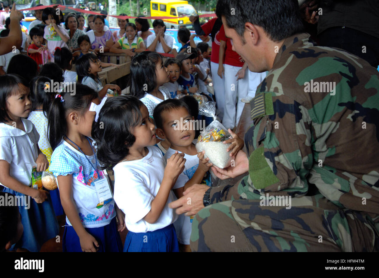 071227-N-7286M-033 BASILAN, Philippines (Dec. 27, 2007) A U.S. Navy SEAL (Sea Air Land) team member hands out rice and canned foods to students of Panunsulan Elementary School on the island of Basilan during a Medical Civic Action Program (MEDCAP).  SEAL Team members participated in the MEDCAP with representatives from Philippine Departments of Education and Health.  U.S. Navy photo by Mass Communication Specialist 1st Class Daniel R. Mennuto (Released) US Navy 071227-N-7286M-033 A U.S. Navy SEAL (Sea Air Land) team member hands out rice and canned foods to students of Panunsulan Elementary Sc Stock Photo