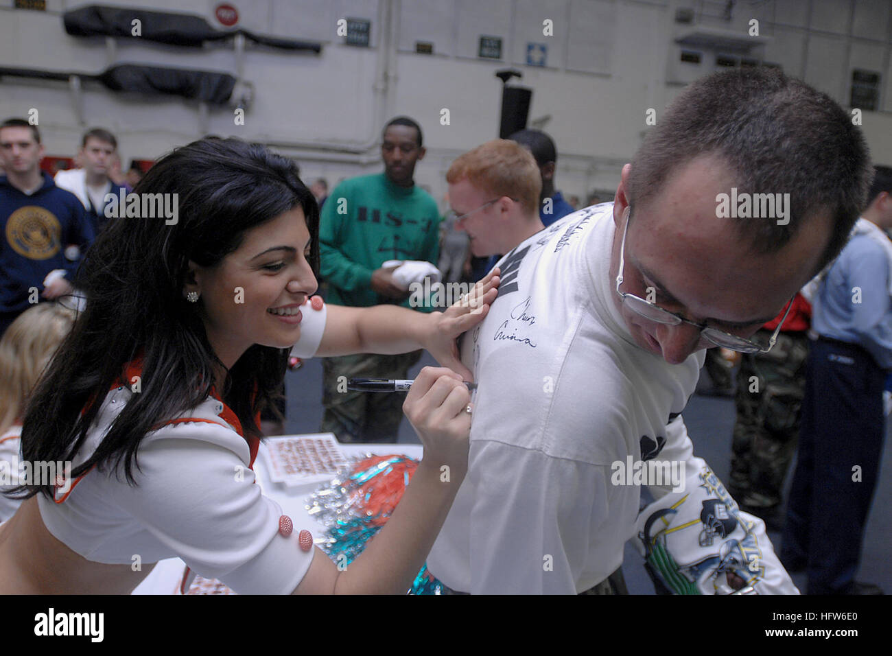 080203-N-5248R-007 ATLANTIC OCEAN (Feb. 3, 2008) Aviation Boatswain's Mate (Handling) 3rd Class Keith Gutkowski, from Keene, N.H., gets his shirt signed by Miami Dolphins cheerleader Ireivy in the hangar bay of the Nimitz-class aircraft carrier USS Theodore Roosevelt (CVN 71). The Roosevelt is conducting carrier qualifications off the Virginia coast. U.S. Navy photo by Mass Communication Specialist 3rd Class Sheldon Rowley (Released) US Navy 080203-N-5248R-007 Aviation Boatswain's Mate (Handling) 3rd Class Keith Gutkowski, from Keene, N.H., gets his shirt signed by Miami Dolphins cheerleader I Stock Photo