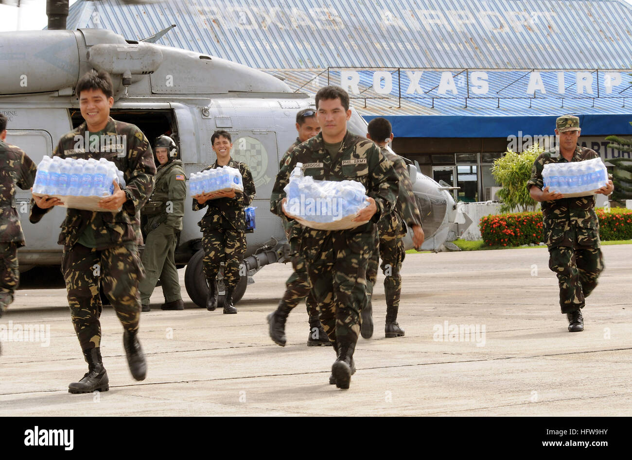 080626-N-5961C-003  ROXAS, Philippines (June 26, 2008) Servicemen of the Philippine Army transport bottled water from an SH-60 helicopter assigned to Helicopter Anti-Submarine Squadron (HS) 4 at Roxas airport. The U.S. Navy and the Philippine Army and Air Force have been working side by side during disaster relief efforts in the wake of Typhoon Fengshen. At the request of the government of the Republic of the Philippines, the Nimitz-class aircraft carrier USS Ronald Reagan (CVN 76) is off the coast of Panay Island providing humanitarian assistance and disaster response. Ronald Reagan and other Stock Photo