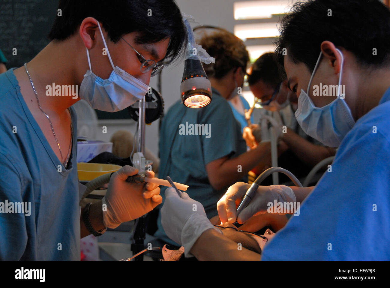 080626-N-9689V-005 NHA TRANG, Vietnam (June 26, 2008) Dr. Viet Tran Trung, right, an East Meets West Foundation volunteer, and John Chan, a University of California, San Diego Pre-dental student, perform dental work on a patient during a Pacific Partnership medical and dental civic action program held at Dien Khanh Primary School in Nha Trang. Medical professionals from Vietnam will work with non-governmental organizations, Vietnamese health care professionals and local government officials providing focused medical care in partnership with American counterparts. U.S. Navy photo by Mass Commun Stock Photo