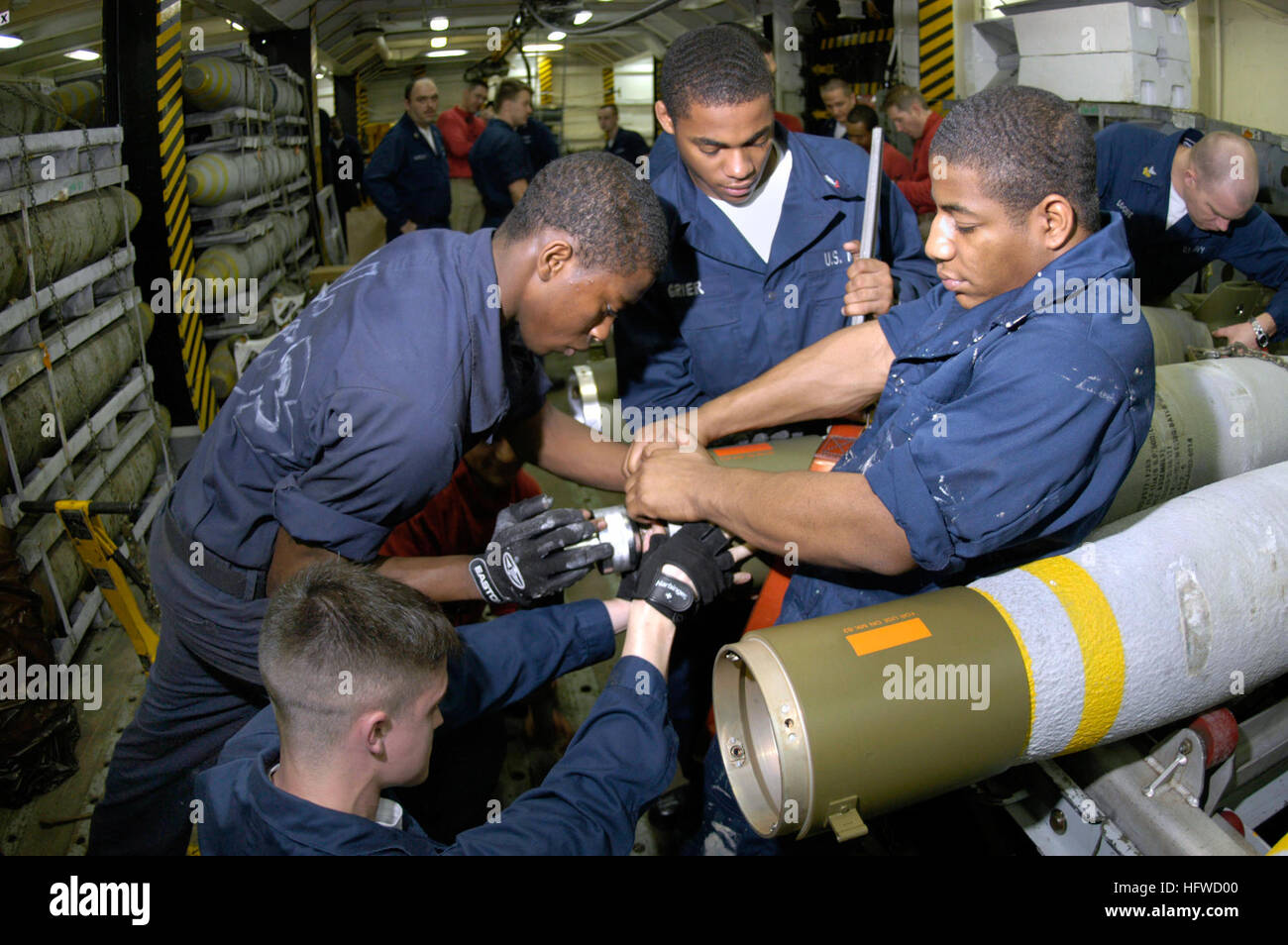 050623-N-5464G-004 Coral Sea (June 23, 2005) Ð Sailors assigned to the Weapons Department transport a weapon skid loaded with three MK-83 1,000-pound general-purpose bombs in the hangar bay aboard the conventionally powered aircraft carrier USS Kitty Hawk (CV 63). Kitty Hawk is currently operating in the Coral Sea in support of Exercise Talisman Sabre 2005. Talisman Sabre is an exercise jointly sponsored by the U.S. Pacific Command and Australian Defence Force Joint Operations Command, and designed to train the U.S. Seventh Fleet commander's staff and Australian Joint Operations staff as a des Stock Photo