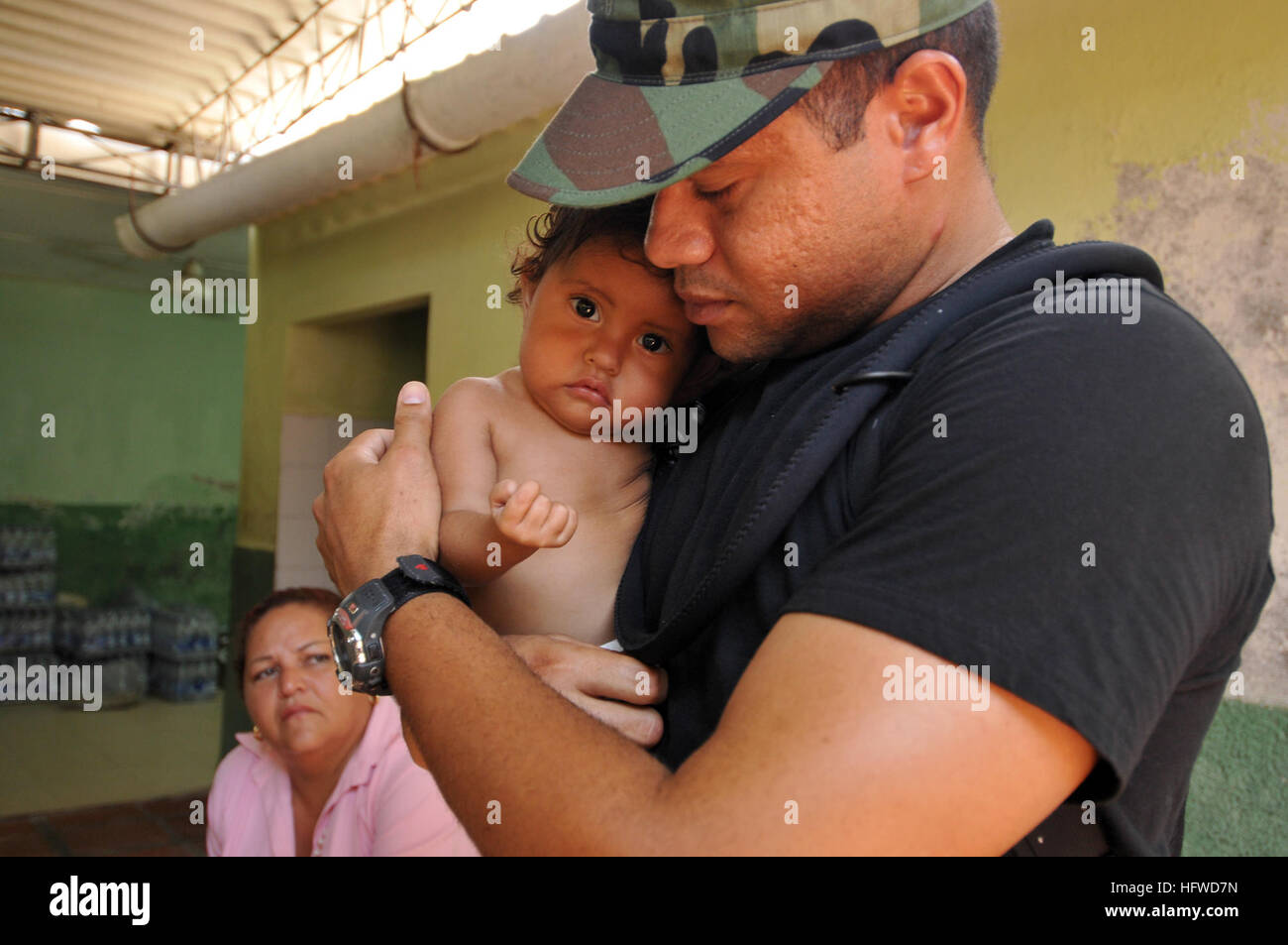 080903-N-8907D-126  PALMIRA, Colombia (Sept. 1, 2008) Machinist Mate 1st Class Samuel Ramos, assigned to the amphibious assault ship USS Kearsarge (LHD 3), comforts a child at the Palmira medical site during the Caribbean phase of Continuing Promise (CP) 2008. CP is an equal partnership mission between the United States, Canada, the Netherlands, Brazil, Nicaragua, Panama, Columbia, Dominican Republic, Trinidad and Tobago and Guyana. U.S. Navy photo by Mass Communication Specialist 3rd Class David Danals (Released) US Navy 080903-N-8907D-126 Machinist Mate 1st Class Samuel Ramos, assigned to th Stock Photo