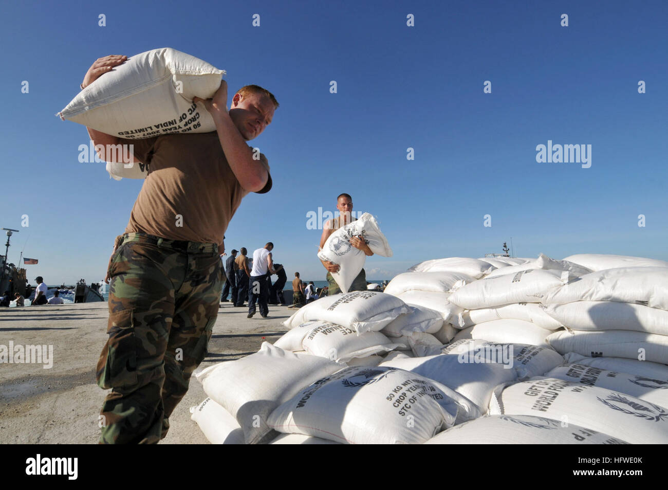 080915-N-8907D-051 GONAIVES, HAITI (Sept. 15, 2008) Hospital Corpsman Shane Leidig, embarked aboard the amphibious assault ship USS Kearsarge (LHD 3), carries a sack of rice during a humanitarian assistance mission in Haiti. Kearsarge has been diverted from the scheduled Continuing Promise 2008 humanitarian assistance deployment in the western Caribbean to conduct hurricane relief operations in Haiti. (U.S. Navy photo by Mass Communication Specialist 3rd Class David Danals/Released) US Navy 080915-N-8907D-051 Hospital Corpsman Shane Leidig, embarked aboard the amphibious assault ship USS Kears Stock Photo