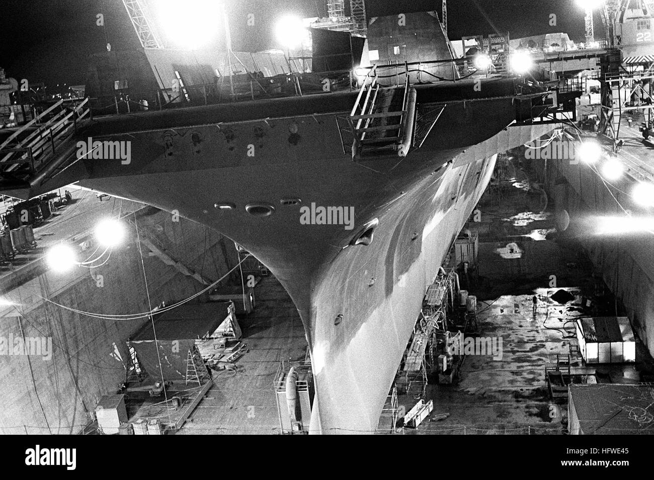 Port bow nighttime view of the aircraft carrier USS KITTY HAWK (CV-63) in dry dock. USS Kitty Hawk (CV-63) docked Stock Photo