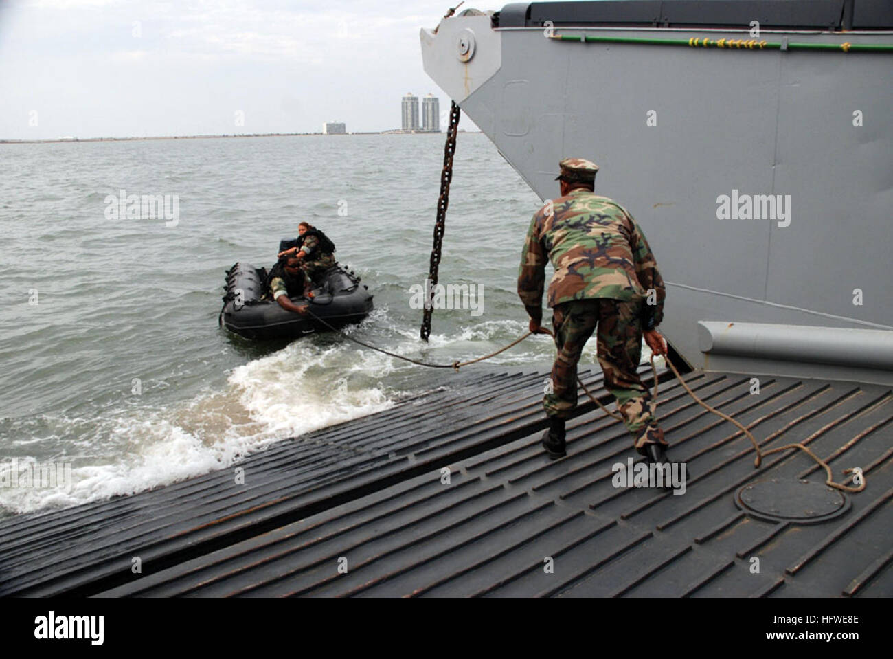 080918-N-0193M-125 GALVESTON, Texas (Sept. 18, 2008) Chief Boswain's Mate Charles Dalton prepares to throw off the last line to Engineman 1st Class John Ne' Smith as he and Boswain's Mate 1st Class Jennifer Smith disembark from a landing craft utility (LCU) from the amphibious assault ship USS Nassau (LHA 4) into a ridged-hull inflatable boat to help the LCU navigate a safe course to shore avoiding underwater debris from Hurricane Ike. Nassau is anchored off Galveston to render disaster response and aid to civil authorities as directed in the wake of Hurricane Ike. (U.S. Navy photo by Mass Com Stock Photo