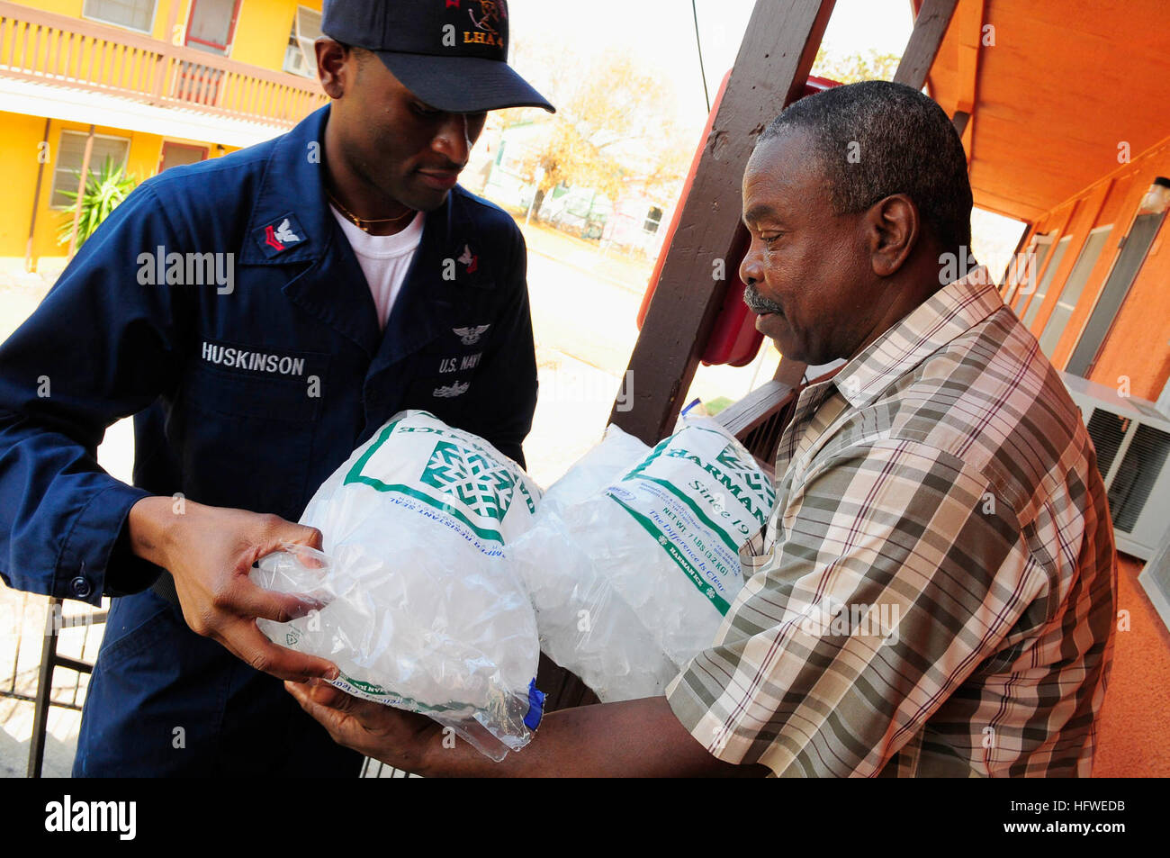 080921-N-5758H-238 GALVESTON, Texas (Sept. 21, 2008) Air Traffic Controller 2nd Class Earle Huskinson, assigned to the amphibious assault ship USS Nassau (LHA 4), gives a bag of ice to Galveston resident Lloyd Smith during a food convoy to various neighborhoods to supply people affected by Hurricane Ike with basic items. Nassau is anchored off the coast of Galveston to support civil authorities in disaster recovery as directed in the wake of Hurricane Ike. U.S. Navy photo by Mass Communication Specialist 3rd Class Kenneth R. Hendrix/Released) US Navy 080921-N-5758H-238 Air Traffic Controller 2 Stock Photo