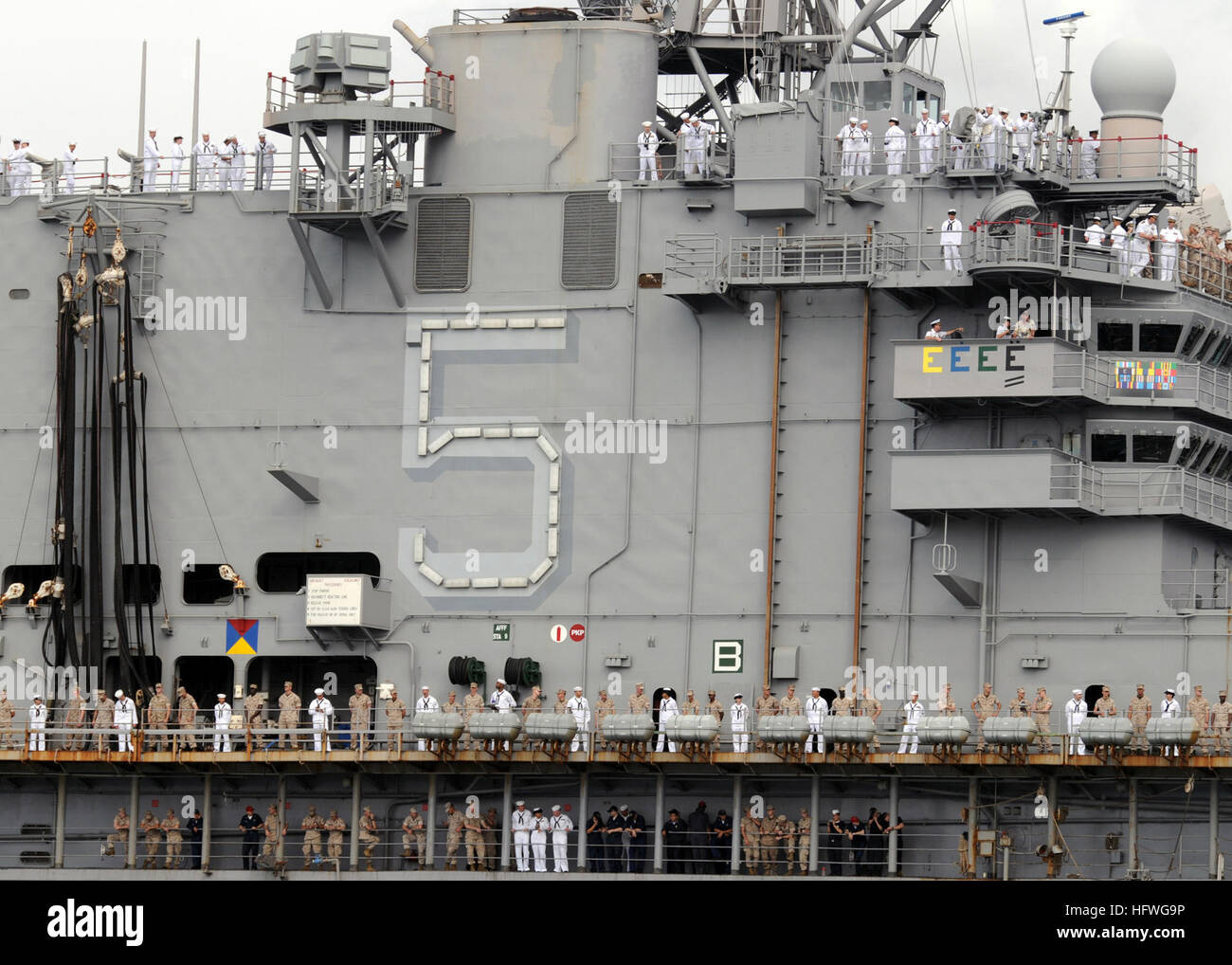 Sailors and Marines aboard USS Peleliu (LHA 5) man the rails as the ...