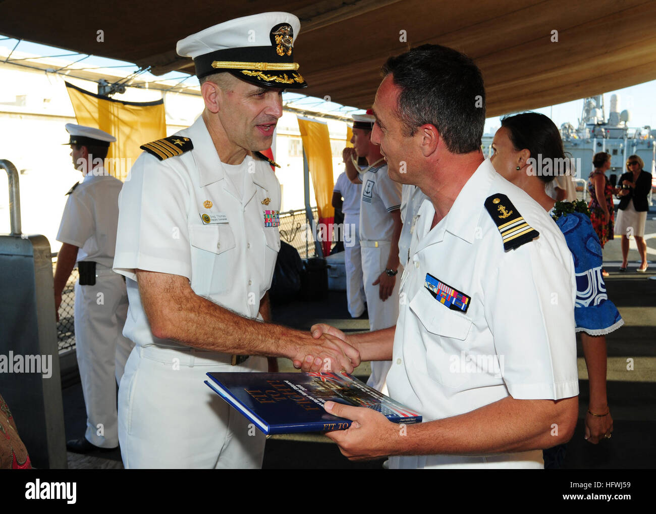 100630-N-3570S-031 PEARL HARBOR (June 30, 2010) Capt. Gregory R. Thomas, commander of Pearl Harbor Naval Shipyard, presents French navy Cmdr. Renaud Bondil, commanding officer of the French navy frigate Prairial (F 731), with a book of Pearl Harbor during the Rim of the Pacific (RIMPAC) 2010 French reception. RIMPAC is a biennial, multinational exercise designed to strengthen regional partnerships and improve interoperability. (U.S. Navy photo by Mass Communication Specialist 2nd Class Jeremy M. Starr/Released) US Navy 100630-N-3570S-031 Capt. Gregory R. Thomas presents French navy Cmdr. Renau Stock Photo