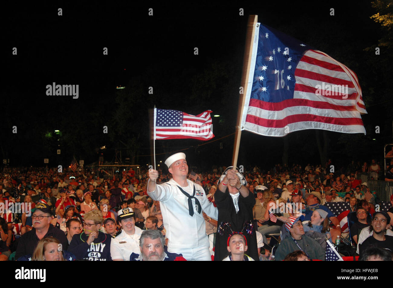 050704-N-1134F-009 Boston, Mass. (July 4, 2005) Ð PhotographerÕs Mate 2nd Class Scott Webb assigned to the Naval Media Center, Anacostia waves an American flag along with another guest dressed in a Revolutionary War costume flying ÒOld GloryÓ during BostonÕs 4th of July celebration. U.S. Navy photo by Chief Journalist Dave Fitz (RELEASED) US Navy 050704-N-1134F-009 Photographer%%5Ersquo,s Mate 2nd Class Scott Webb assigned to the Naval Media Center, Anacostia waves an American flag Stock Photo