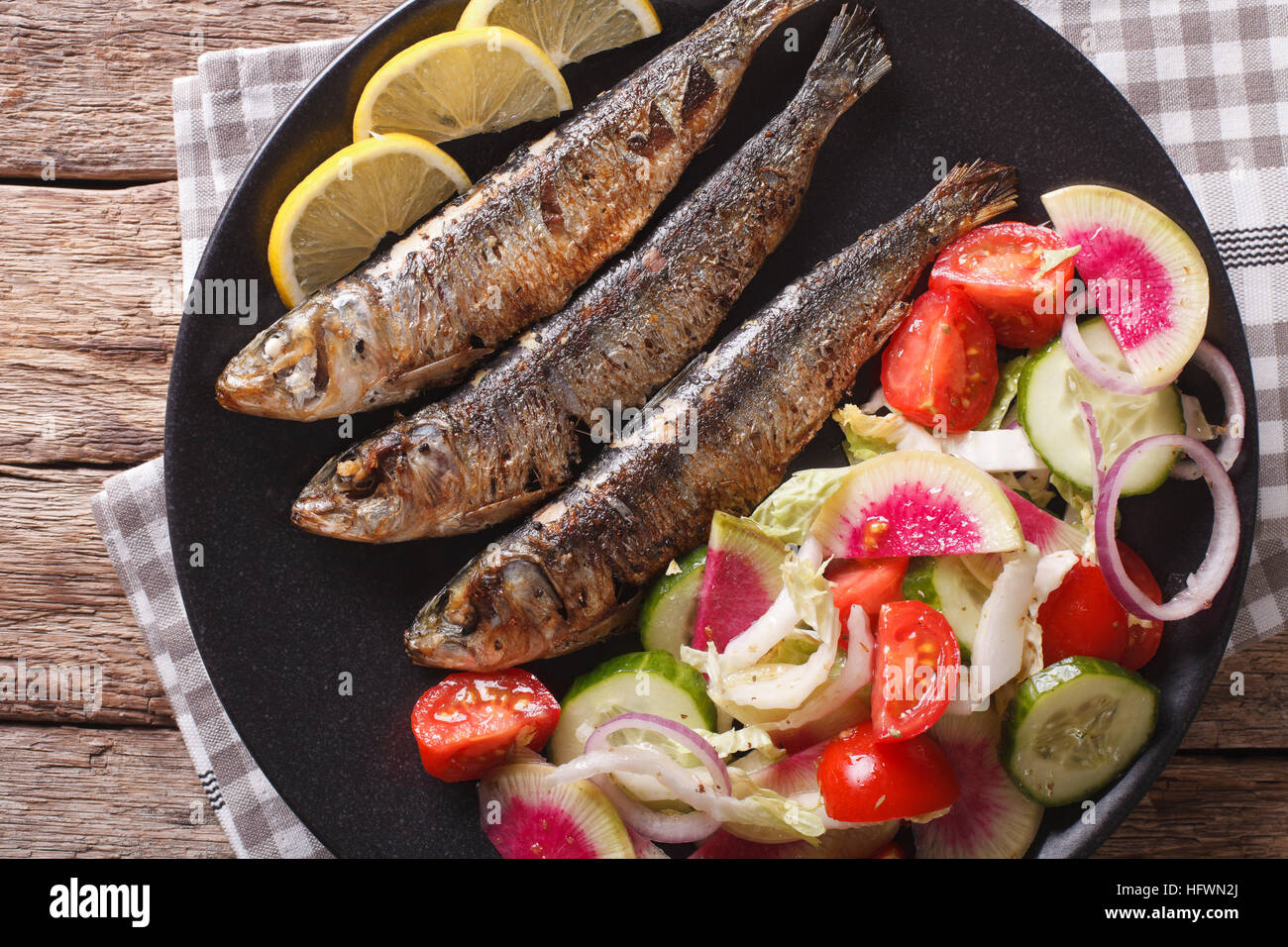 Mediterranean food grilled sardines with fresh vegetable salad close