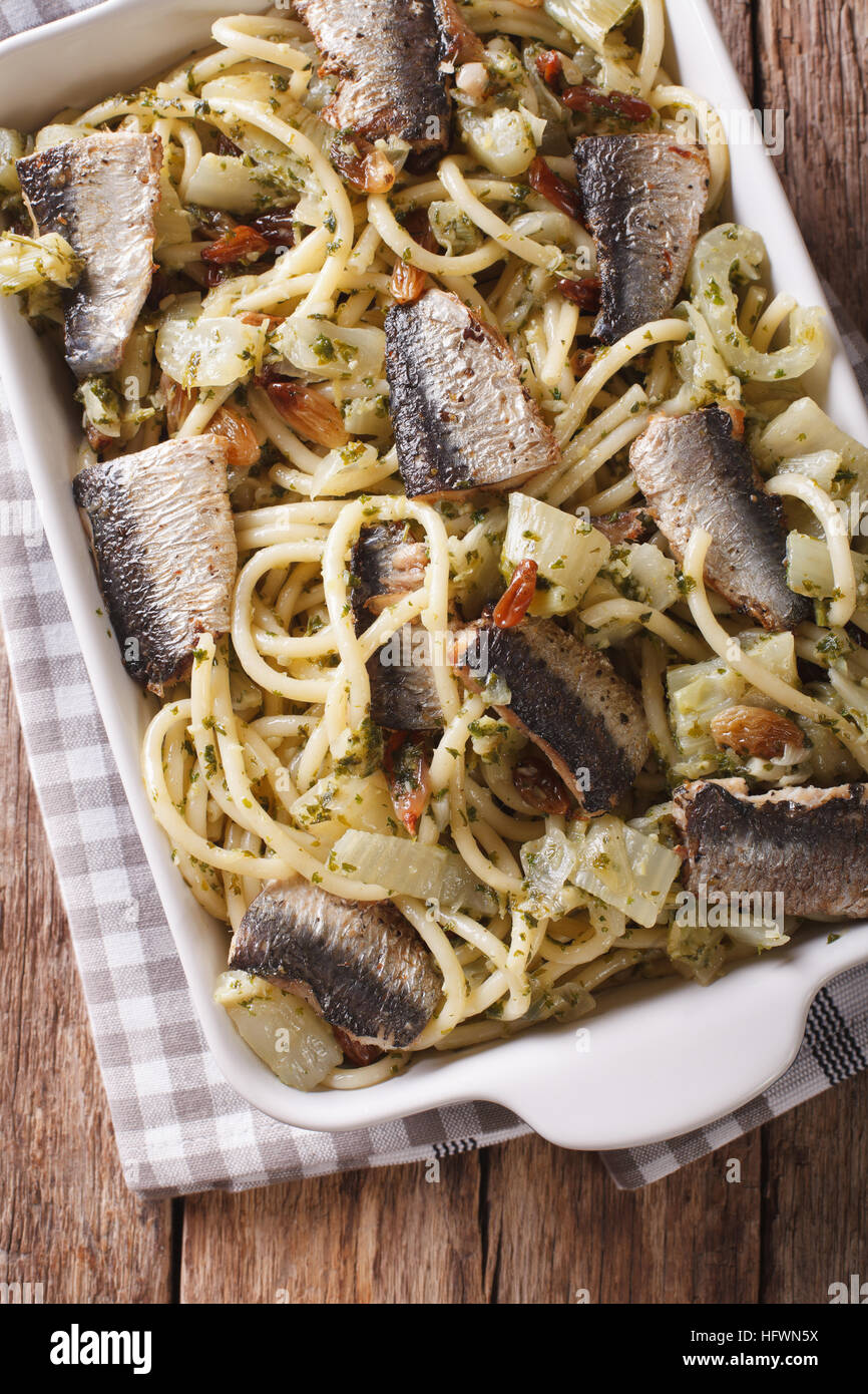 Italian pasta bucatini with sardines, fennel, raisins and pine nuts close up in baking dish. vertical view from above Stock Photo