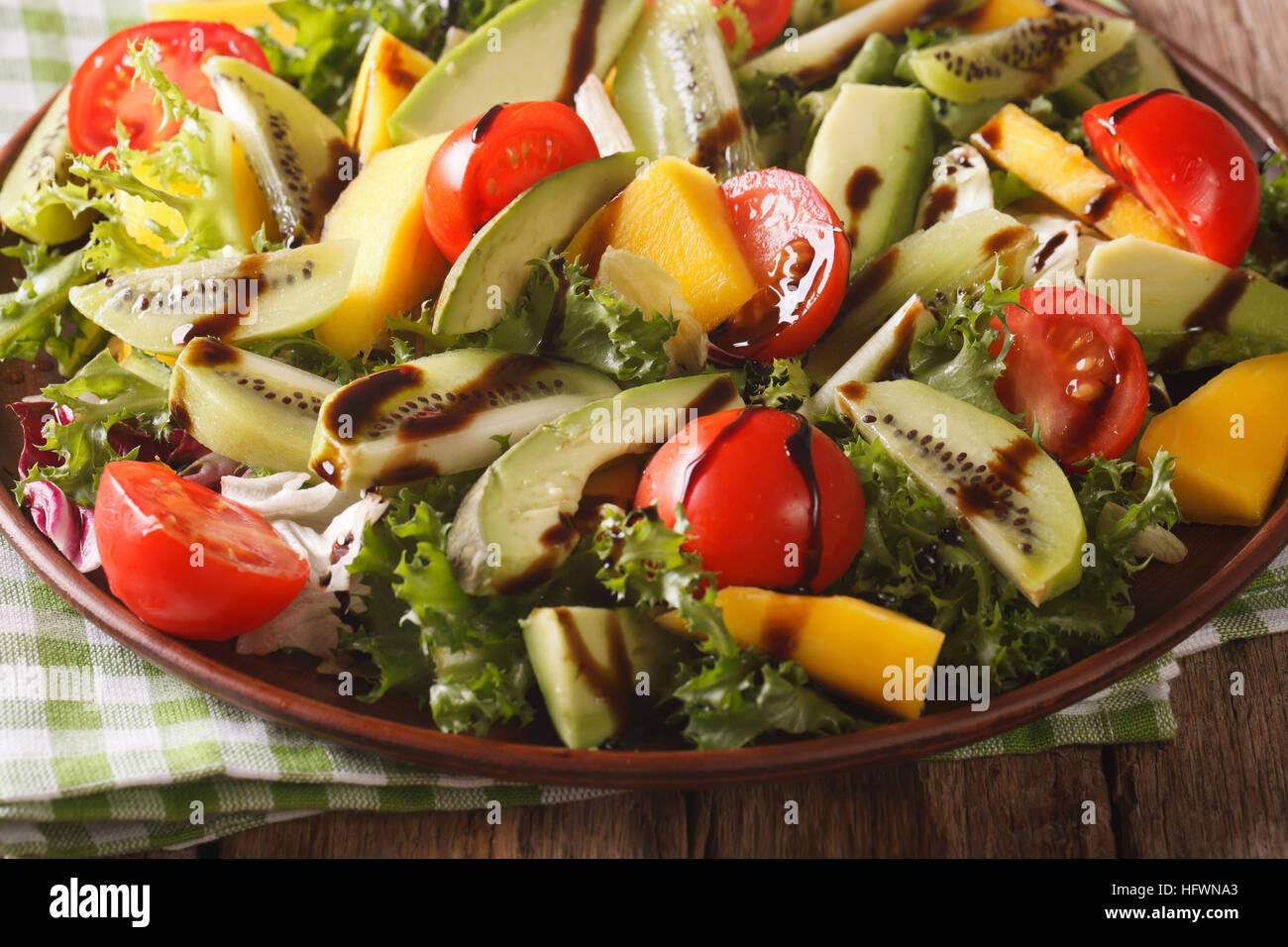 Fruit vegetable salad of mango, avocado, kiwi, tomato and lettuce on a plate close-up. horizontal Stock Photo