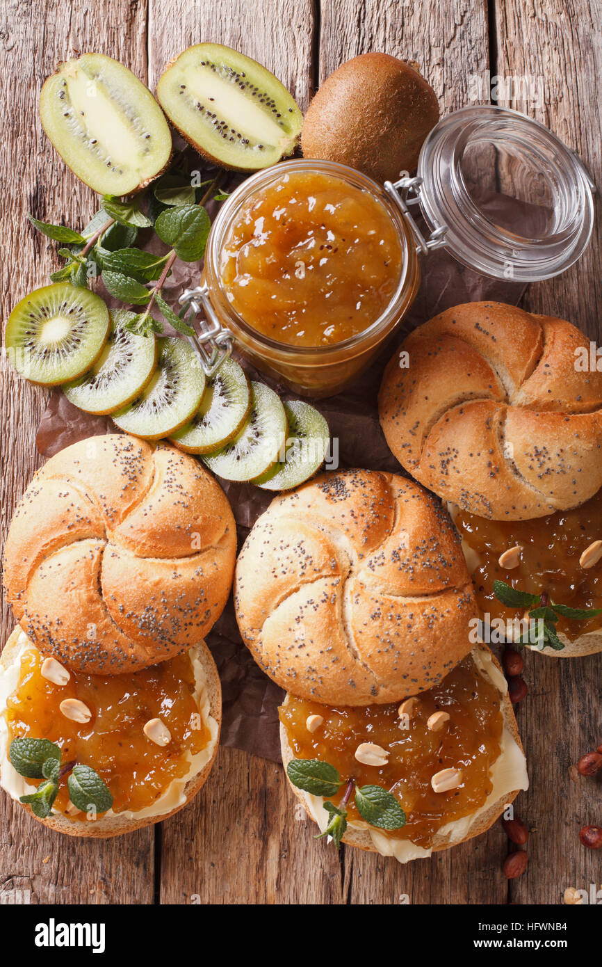Sweet rolls with butter, jam kiwi, mint and peanuts closeup on the