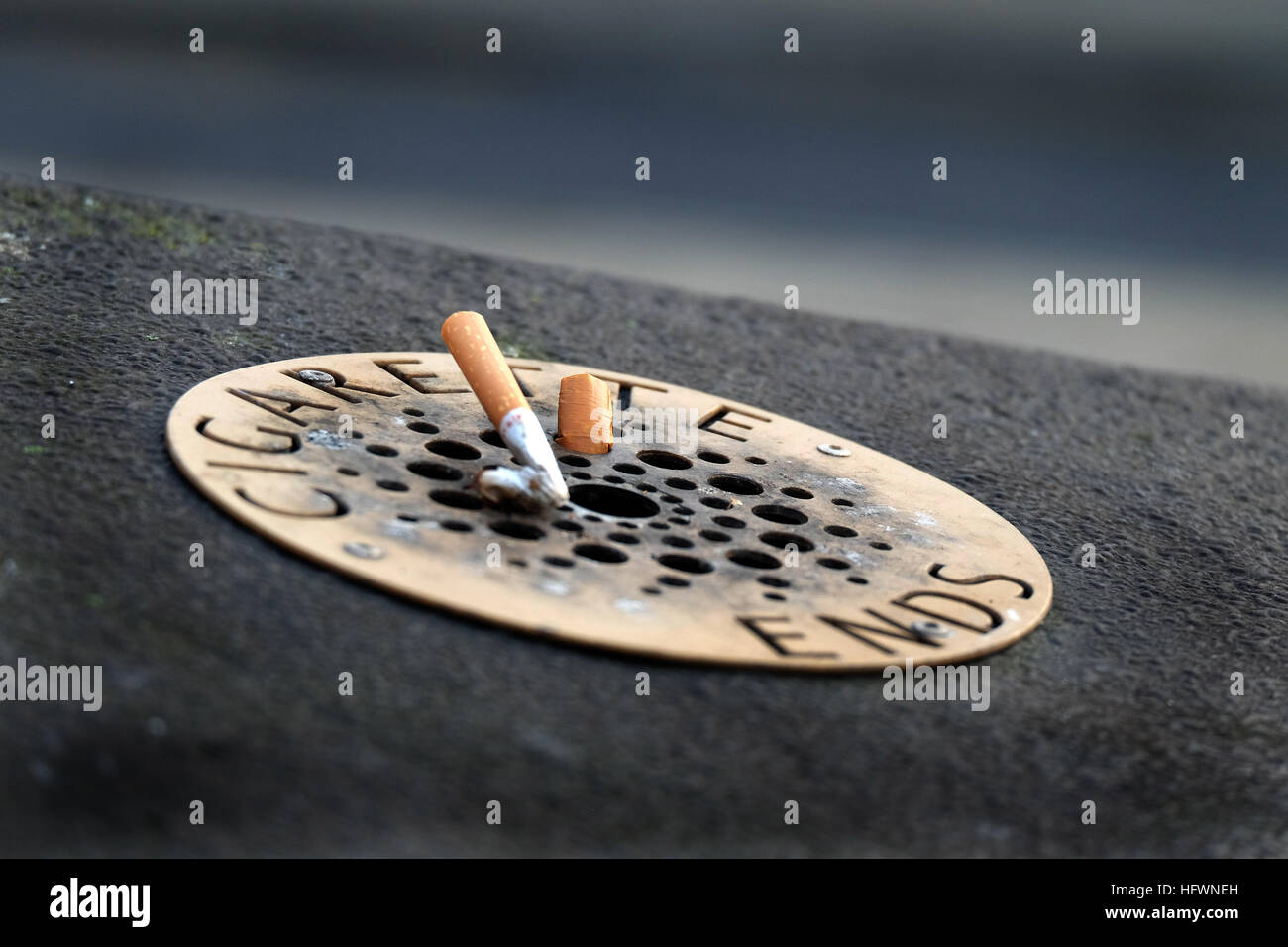 Stubbed cigarette ends on street bin. Stock Photo