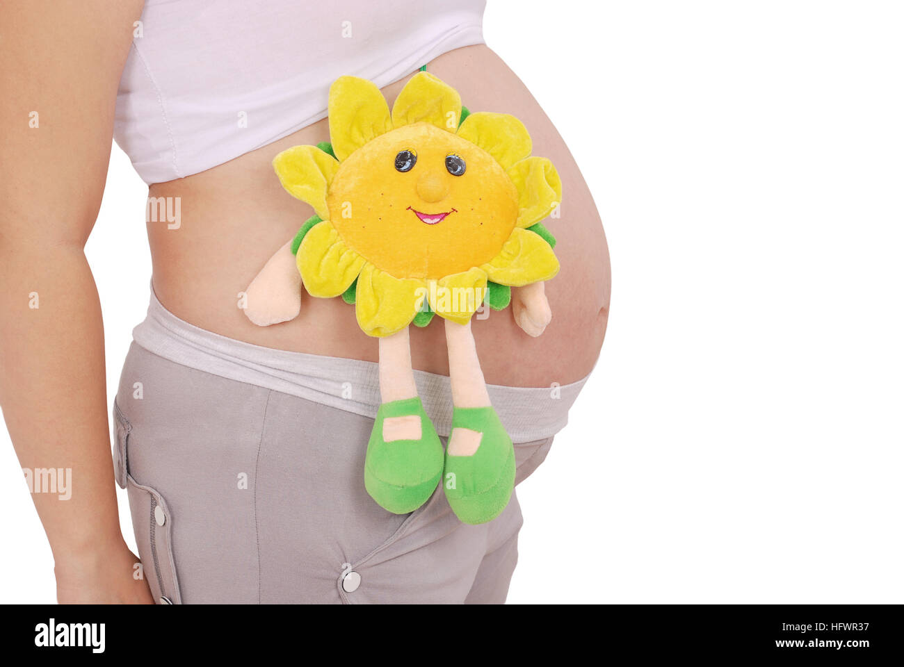 Pregnant woman has put the toy to the stomach on grey background Stock Photo