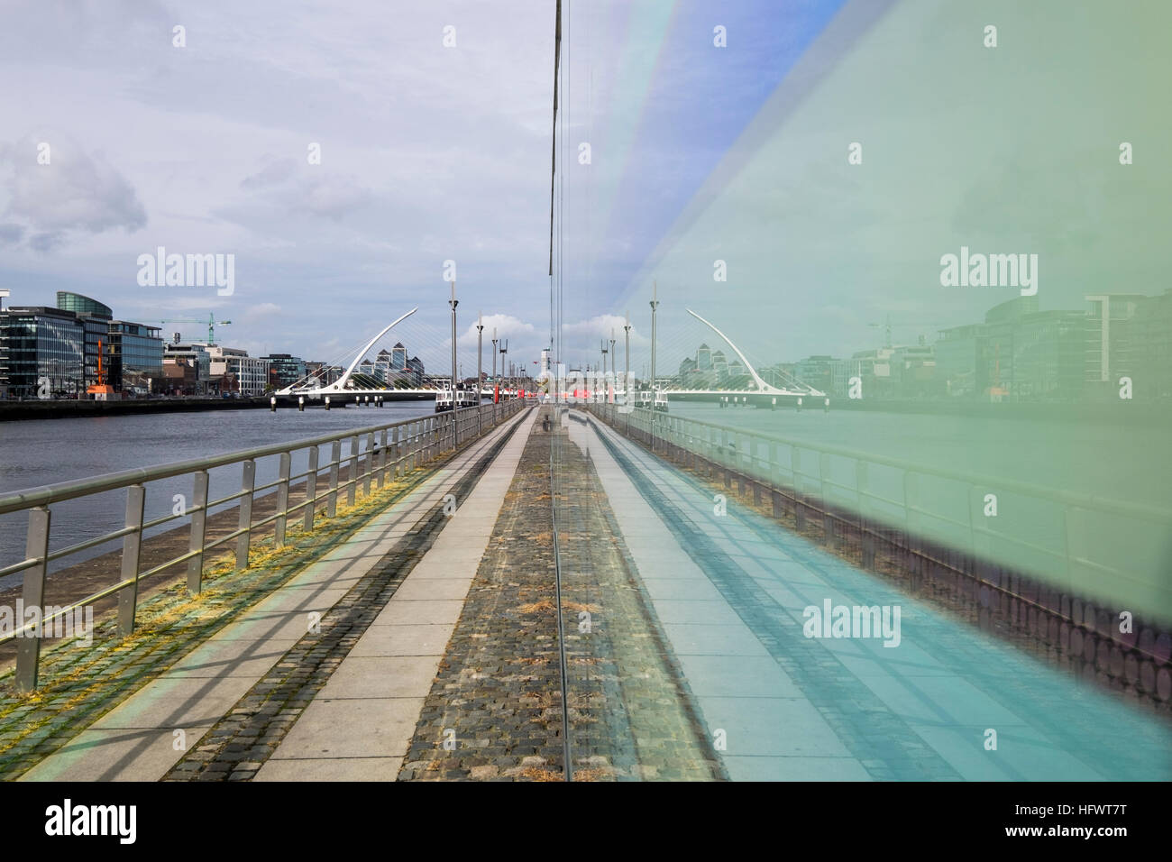Samuel Beckett bridge over the river Liffey seen mirrored in a coloured glass wall of a building on North Wall Quay, Dublin, Ireland Stock Photo