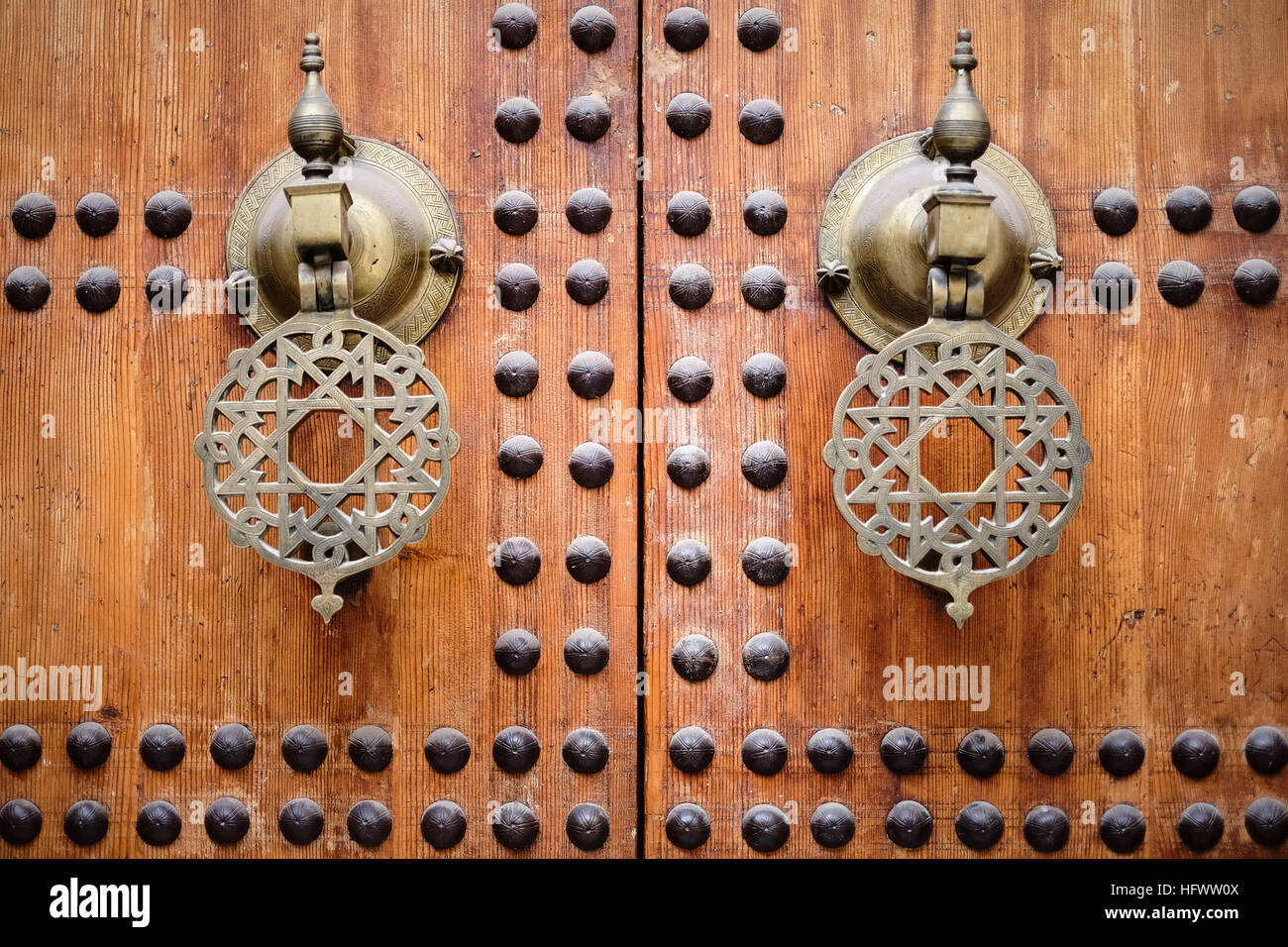 Elaborate door handles / knockers on studded wooden doors of the