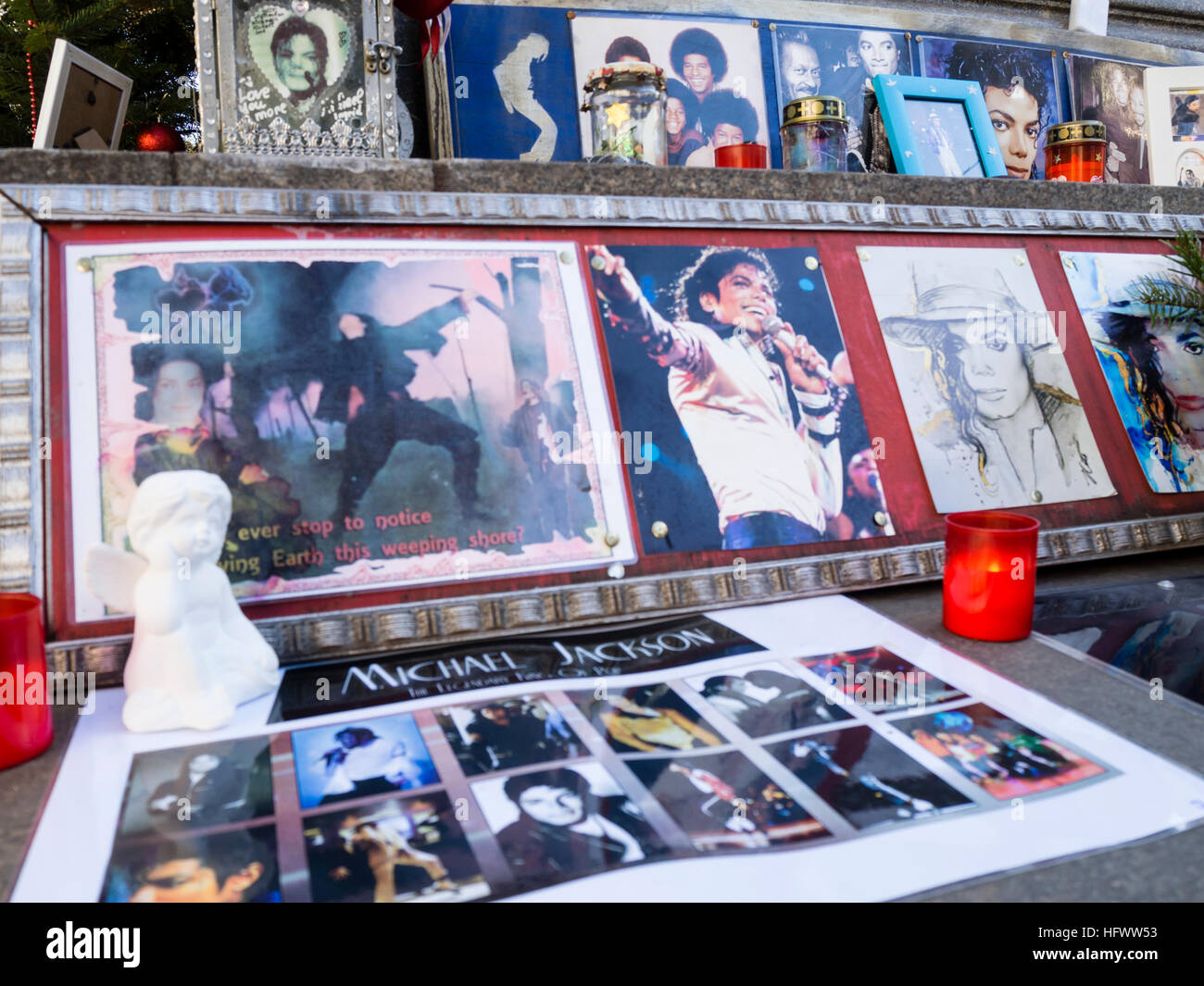 Munich, Germany - 29 December 2016: Votive candles, pictures and memorabilia of the late pop star Michael Jackson, placed by his fans at the so called 'Michael Jackson Memorial' at Munich's Promenadeplatz across the hotel 'Bayerischer Hof'. Since the death of the artist in 2009, the historic stone monument of Orlando di Lasso has been converted into a shrine and memorial by fans of the 'King of Pop' who used to occupy a suite at the nearby luxury hotel when staying in Munich. Stock Photo