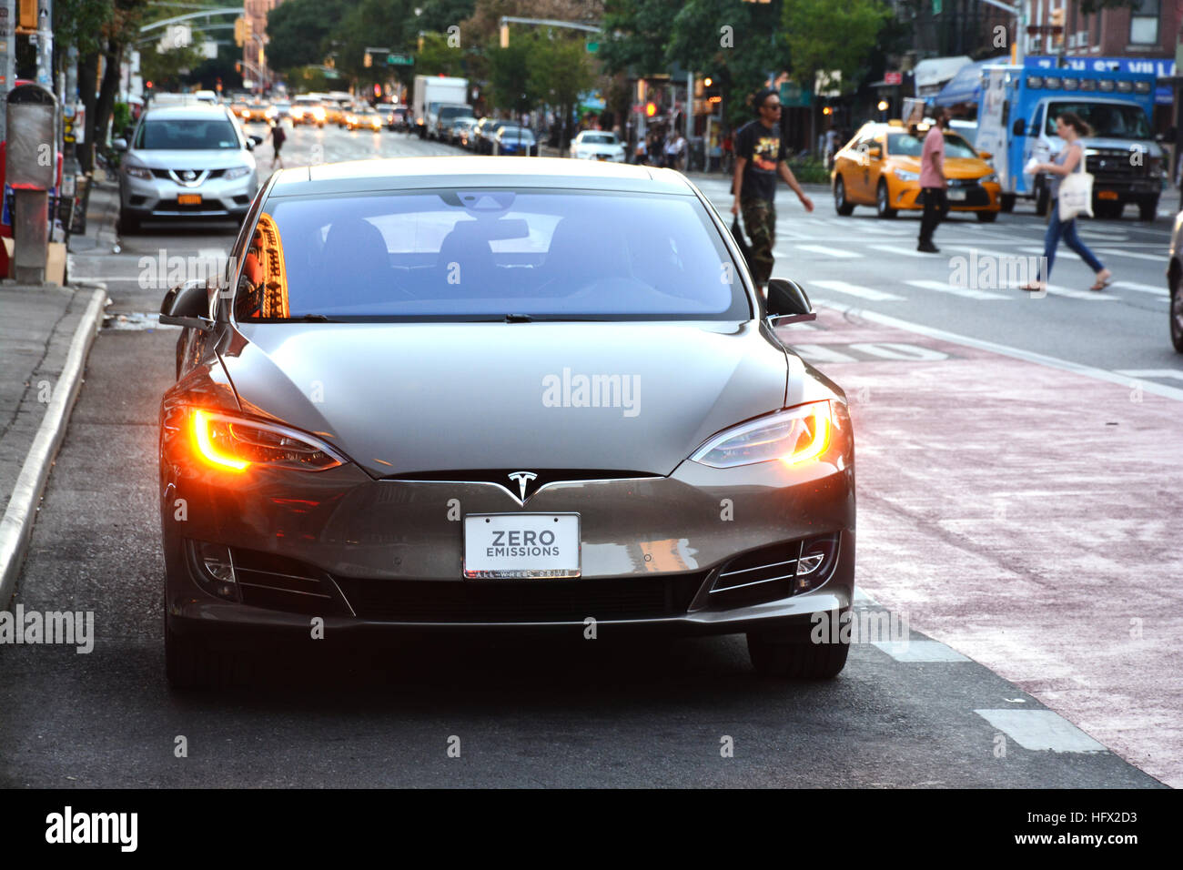Tesla electric car with ZERO EMISSIONS text on the license plate waiting at traffic lights Stock Photo