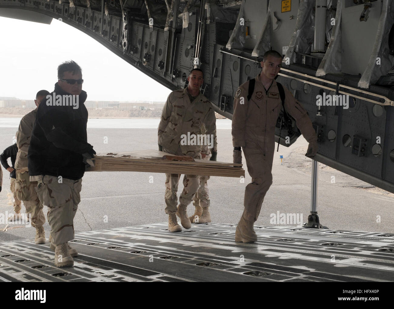 090109-N-1120L-044 AL TAQQADUM, Iraq (Jan. 9, 2009) Seabees assigned to Naval Mobile Construction Battalion (NMCB) 7 move approach shoring used to load a bulldozer onto an Air Force C17 aircraft. NMCB-7 is deployed to U.S. Forces Central Command area of responsibility to support Operation Iraqi Freedom and Operation Enduring Freedom. (U.S. Navy photo by Mass Communication Specialist 2nd Class Michael B. Lavender/Released) US Navy 090109-N-1120L-044 Seabees move approach shoring onto an Air Force C17 aircraft Stock Photo