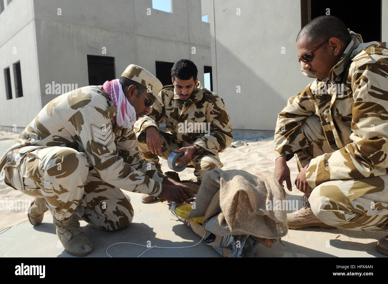 090115-N-8730P-006 BAHRAIN (Jan. 15, 2009) Bahrain Royal Field Engineers examine a simulated improvised explosive device (IED) as part of a bomb disposal training scenario given by Explosive Ordnance Disposal Mobile Unit (EODMU) 2 at a Bahraini military training range during Neon Response 2009. Neon Response is a bilateral explosive ordnance disposal (EOD) engagement between the U.S. Navy, Royal Bahrain Navy and Bahrain Defense Force Engineer Regiment EOD Forces. (U.S. Navy photo by Mass Communication Specialist 2nd Class Charles Panter/Released) US Navy 090115-N-8730P-006 Bahrain Royal Field  Stock Photo