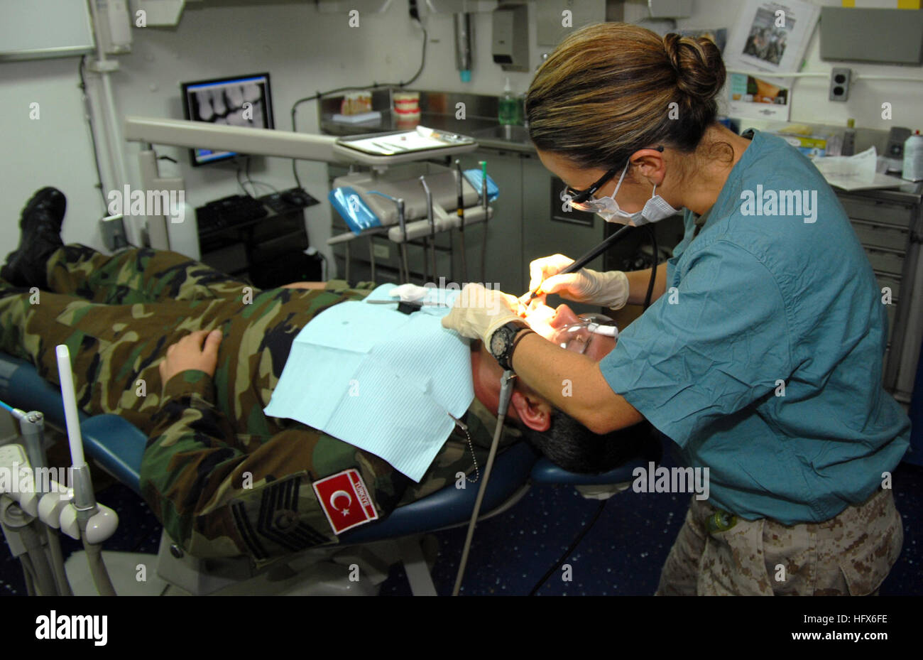 090313-N-9761H-007 PERSIAN GULF (March 13, 2009) Lt. Angela Roldan-Whittaker, dental officer for the 13th Marine Expeditionary Unit embarked aboard the amphibious assault ship USS Boxer (LHD 4), provides a routine dental cleaning for a Turkish master chief petty officer assigned to the Turkish Naval Forces ship TCG Giresun. Boxer is deployed as part of Boxer Amphibious Readiness Group/13th Marine Expeditionary Unit supporting maritime security operations in the U.S. 5th Fleet area of responsibility. (U.S. Navy photo by Mass Communication Specialist 2nd Class Jeff Hopkins/Released) US Navy 0903 Stock Photo