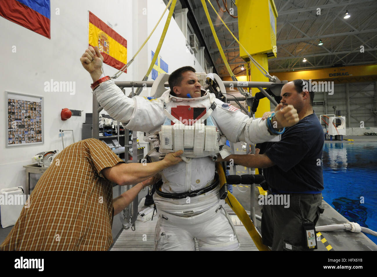 090324-N-2959L-143 HOUSTON (March 24, 2009) Lt. Cmdr. Chris Cassidy receives help donning his space suit before a training session at the Neutral Buoyancy Laboratory (NLB) in Houston. The air-and-water-tight space suit will be pressurized with an additional four pounds of pressure per square inch to simulate the suit weight astronauts experience during spacewalks. The NBL is a pool that simulates zero gravity to train astronauts for upcoming missions. The NBL contains full mock-ups of the International Space Station for the astronauts to train with. Cassidy, a U.S. Navy SEAL, is a mission spec Stock Photo