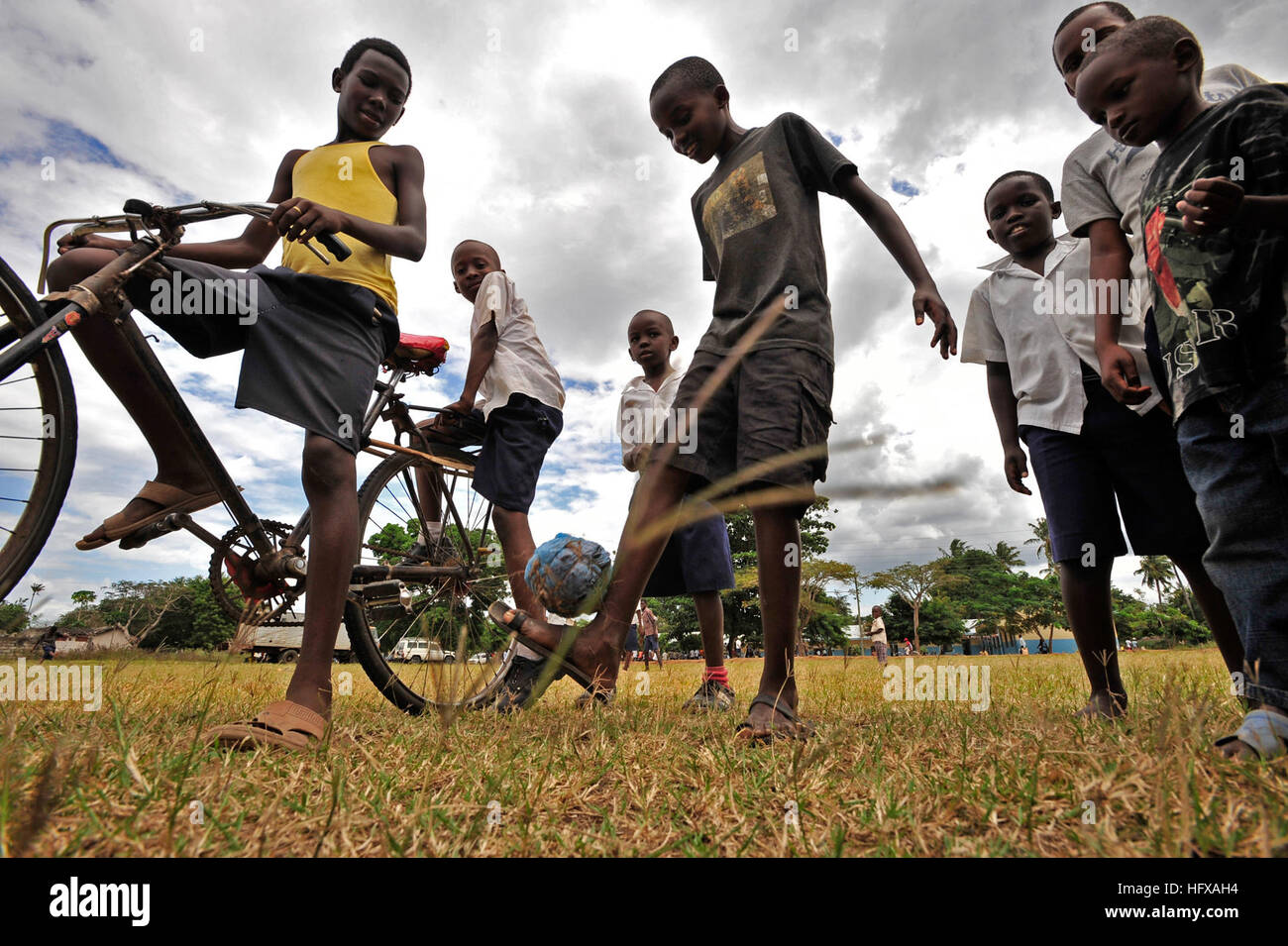 A boy kicks a soccer ball made of plastic bags on his head before a