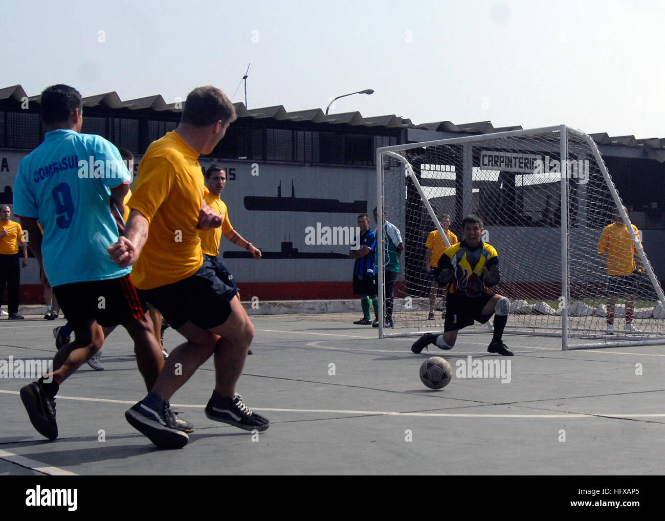 090612-N-4879G-615 CALLAO, Peru-(June 12, 2009) A Sailor assigned to the guided-missile frigate USS Ford (FFG 54) kicks the ball at the Peruvian Submarine Forces goal as one of their sailors drops down to block it during a multi-national soccer tournament on the Peruvian naval base. Doyle is deployed as part Southern Seas 2009, a US Southern Command (SOUTHCOM) Partnership of the Americas strategy, and focuses on strengthening the relationship in the SOUTHCOM Area of Focus. This years deployment includes the guided-missile frigates USS Doyle (FFG 39), USS Kauffman (FFG 59), and USS Ford (FFG 54 Stock Photo