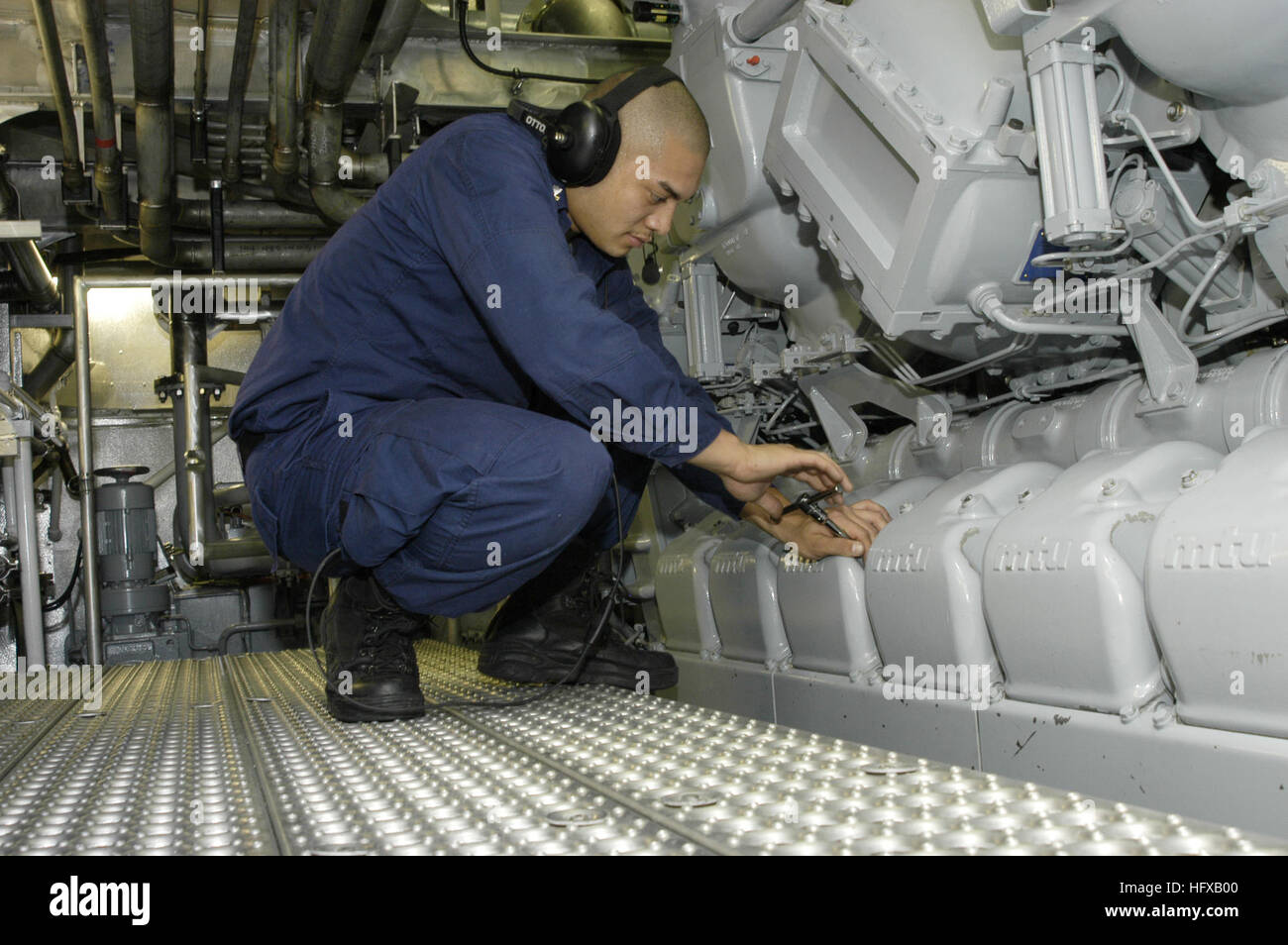 050720-N-6477M-033 Everett, Wash. (July 20, 2005) - U.S. Coast Guard Machinery Technician 2nd Class Joshua Byrd opens the Blow Down Valves to clean out the cylinders of the number one diesel during Light Off Assessment (LOA) aboard the new littoral Surface Craft-Experimental (X-Craft), christened Sea Fighter (FSF-1). LOA assesses the engineering Training Team and Damage Control Training Team to make sure they are capable of training the ship. It also takes a hard look at the equipment aboard the ship to make sure it is safe to operate and is a requirement for all Navy ships being put into serv Stock Photo