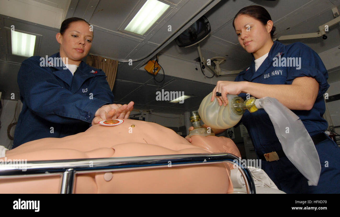 070326-N-4207-026  SOUTH CHINA SEA (March 26, 2007) - Hospital Corpsman 2nd Class Christy Harrison and 3rd Class Christina Calderon practice cardiopulmonary resuscitation (CPR) on a training dummy on board amphibious assault ship USS Essex (LHD 2). Essex was awarded her eleventh consecutive Green ÔHÕ award attesting to the shipÕs commitment to health excellence. U.S. Navy photo by Mass Communication Specialist Jhoan Montolio (RELEASED) US Navy 070326-N-4207M-026 Hospital Corpsman 2nd Class Christy Harrison and 3rd Class Christina Calderon practice cardiopulmonary resuscitation (CPR) on a train Stock Photo