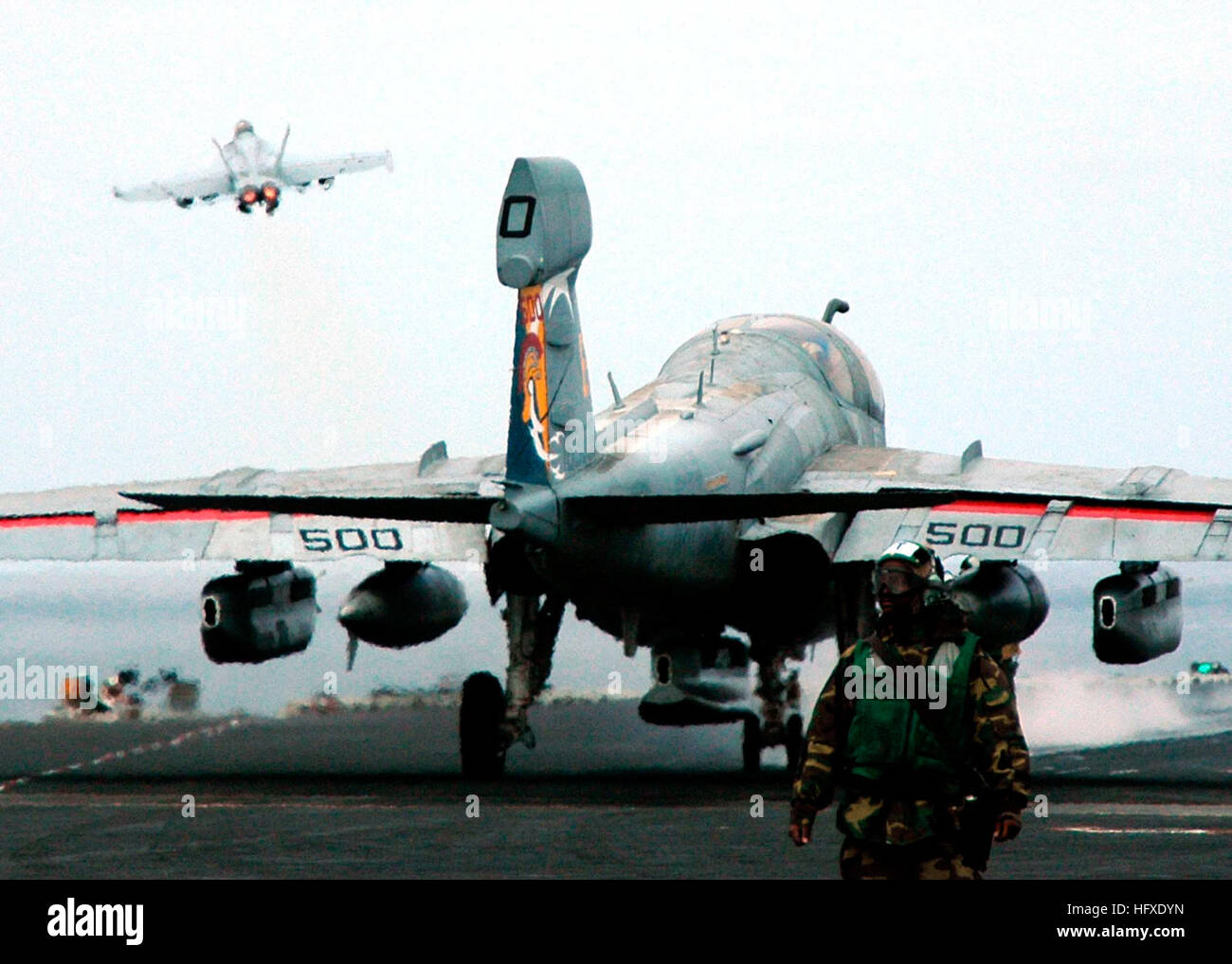 050919-N-5384B-088 Pacific Ocean (Sept. 19, 2005) - As a EA-6B Prowler, assigned to the ÒLancersÓ of Electronic attack Squadron One Three One (VAQ-131), prepares for take off, an F/A-18 Super Hornet launches from the waist catapult of the Nimitz-class aircraft carrier USS Abraham Lincoln (CVN 72). Lincoln and embarked Carrier Air Wing Two (CVW-2) are currently conducting Quarterly Surge Sustainment Training off the coast of Southern California. U.S. Navy photo by Photographer's Mate Airman Justin R. Blake (RELEASED) US Navy 050919-N-5384B-088 As a EA-6B Prowler, assigned to the Lancers of Elec Stock Photo