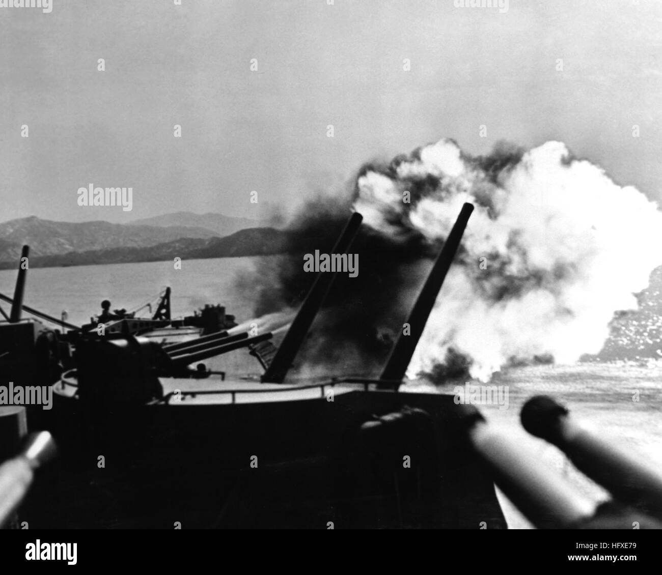 USS TOLEDO (CA-133) hurl tons of hot steel on communist installations in the Wonsan Harbor area. NARA FILE #:  80-G-478495 USS Toledo CA-133 firing salvo 1952 Stock Photo