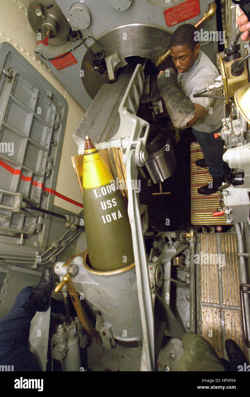 A 1,900-pound high capacity (HC) projectile is hoisted up to the spanning tray of the center Mark 7 15-inch/50-caliber gun in the No. 2 turret aboard the battleship USS IOWA (BB-61).  This particular projectile will be the 1,000th round fired by the IOWAs 16-inch guns since the ship's recommissioning. USS Iowa (BB-61) projectile hoisted to spanning tray Stock Photo