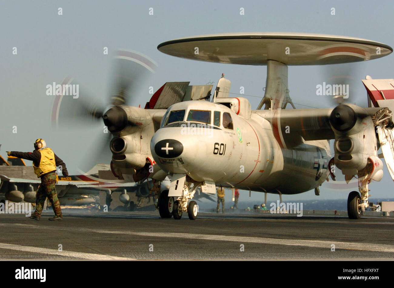 051111-N-3488C-004 Pacific Ocean (Nov. 11, 2005) - An Aviation Boatswain’s Mate directs an E-2C Hawkeye, assigned to the “Liberty Bells” of Carrier Airborne Early Warning Squadron One One Five (VAW-115), during flight operations aboard the conventionally powered aircraft carrier USS Kitty Hawk (CV 63). Kitty Hawk and embarked Carrier Air Wing Five (CVW-5) are currently conducting operations in the Western Pacific Ocean. U.S. Navy photo by Photographer’s Mate 3rd Class Jonathan Chandler (RELEASED) US Navy 051111-N-3488C-004 An Aviation Boatswain%%5Ersquo,s Mate directs an E-2C Hawkeye, assigned Stock Photo