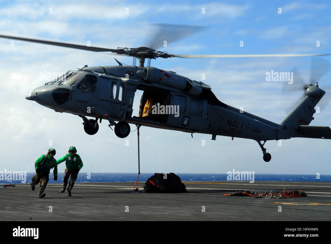 Aviation boatswain's mates secure a cargo net to an SH-60S Seahawk ...