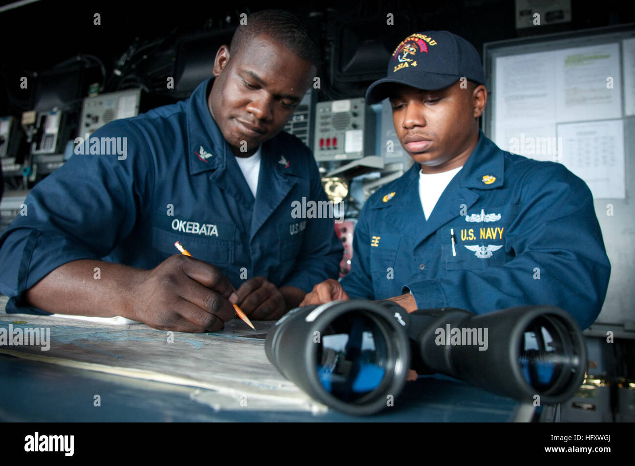 091024-N-5319A-002 ATLANTIC (October 24, 2009) Quartermaster 3rd Class Oscar Okebata, left, from Philadelphia, and acting junior Officer of the Deck Chief Operations specialist Duran Lee, from West Point, Miss., read the chart table aboard the amphibious assault ship USS Nassau (LHA 4) to determine where the ship will be at a given time for the officer of the deck. Nassau is conducting a Composite Unit Training Exercise (COMPTUEX). COMPTUEX is designed to provide realistic training environments for U.S. naval forces that closely replicate the operational challenges routinely encountered during Stock Photo