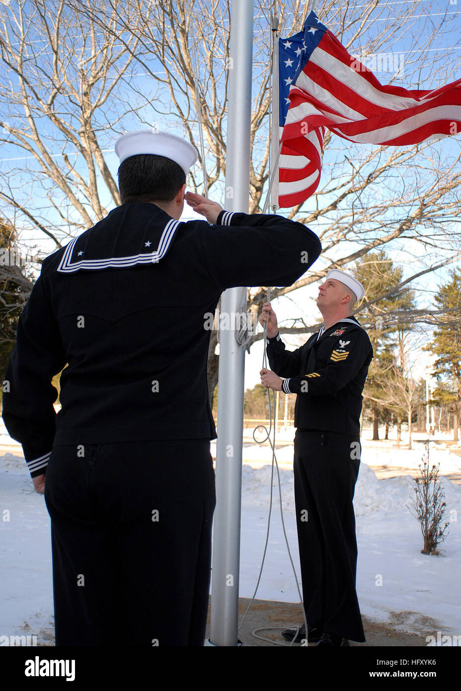 091223-N-9898L-006 NAVAL AIR STATION BRUNSWICK (Dec. 23, 2009) Aviation Electronics Technician 2nd Class Alejandro Benavides renders honors as Aviation Structural Mechanic 1st Class Andrew Johnson lowers the American flag outside of the Navy Operational Support Center (NOSC) Brunswick, Maine, drill hall before a disestablishment ceremony. (U.S. Navy photo by Mass Communication Specialist 3rd Class Geoffrey Lewis/Released) US Navy 091223-N-9898L-006 Aviation Electronics Technician 2nd Class Alejandro Benavides renders honors as Aviation Structural Mechanic 1st Class Andrew Johnson lowers the Am Stock Photo
