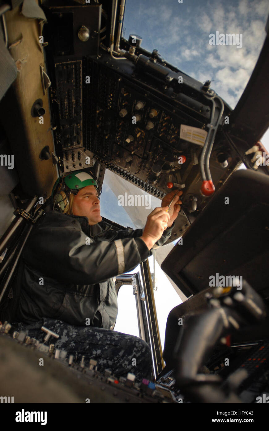 100114-N-8590G-002  MAYPORT, Fla. (Jan. 14, 2010) Aviation Electricians Mate 1st Class Ihosvani A. Diaz, assigned to Helicopter Anti-Submarine Squadron Light (HSL) 46, performs maintenance as naval air crewmen conduct preflight inspections at Naval Station Mayport before departing to embark aboard the guided-missile cruiser USS Normandy (CG 60). The ship and several Navy vessels are underway to provide humanitarian assistance in the aftermath of a 7.0 magnitude earthquake. (U.S. Navy photo by Mass Communication Specialist 2nd Class Gary B. Granger Jr./Released) US Navy 100114-N-8590G-002 Aviat Stock Photo