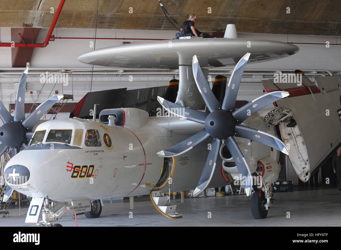 Crew members of VAW-125 perform maintenance on the rotodome of an E-2C ...